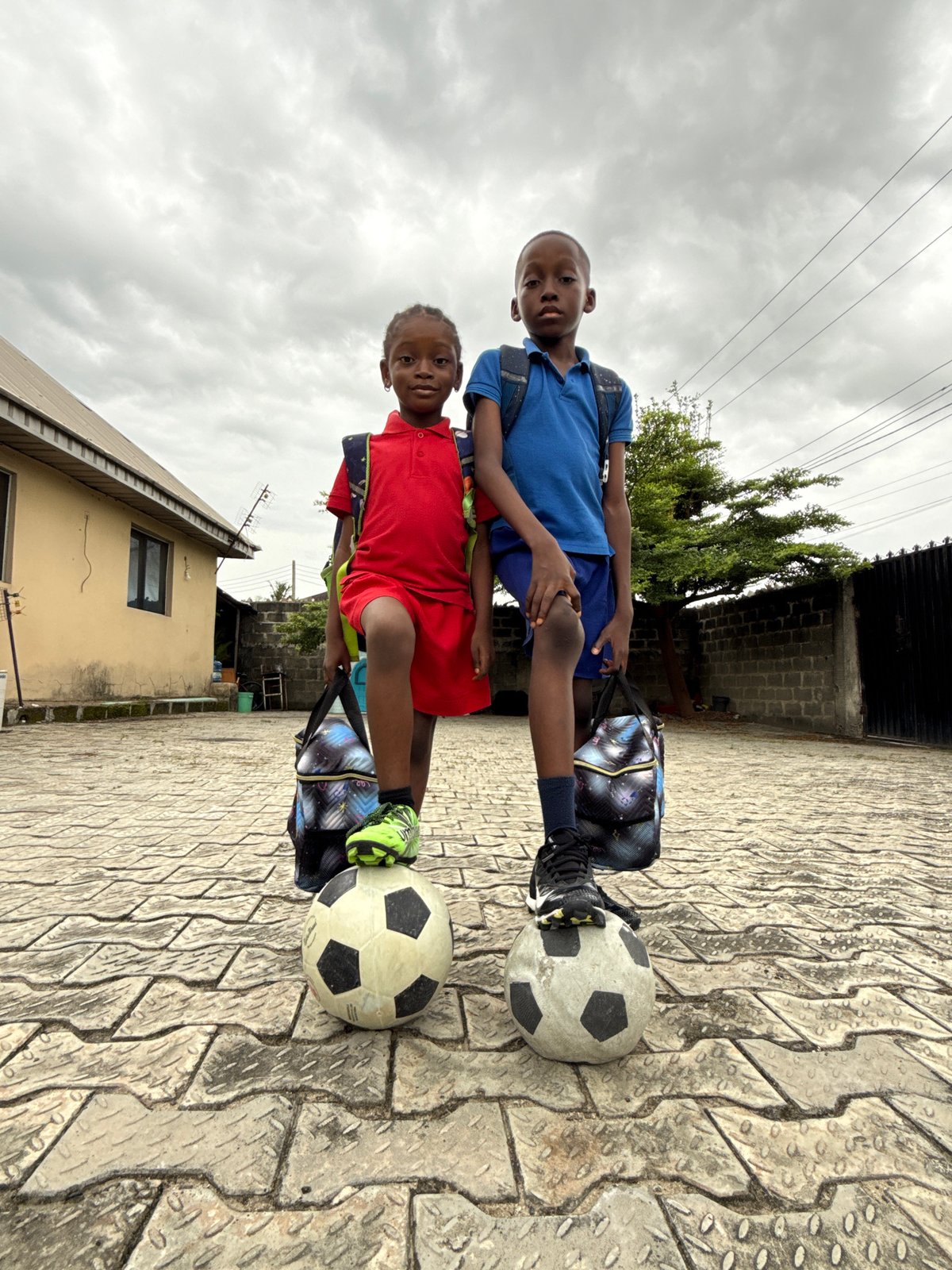 Two boys with soccer balls spotted on pavement in Ado