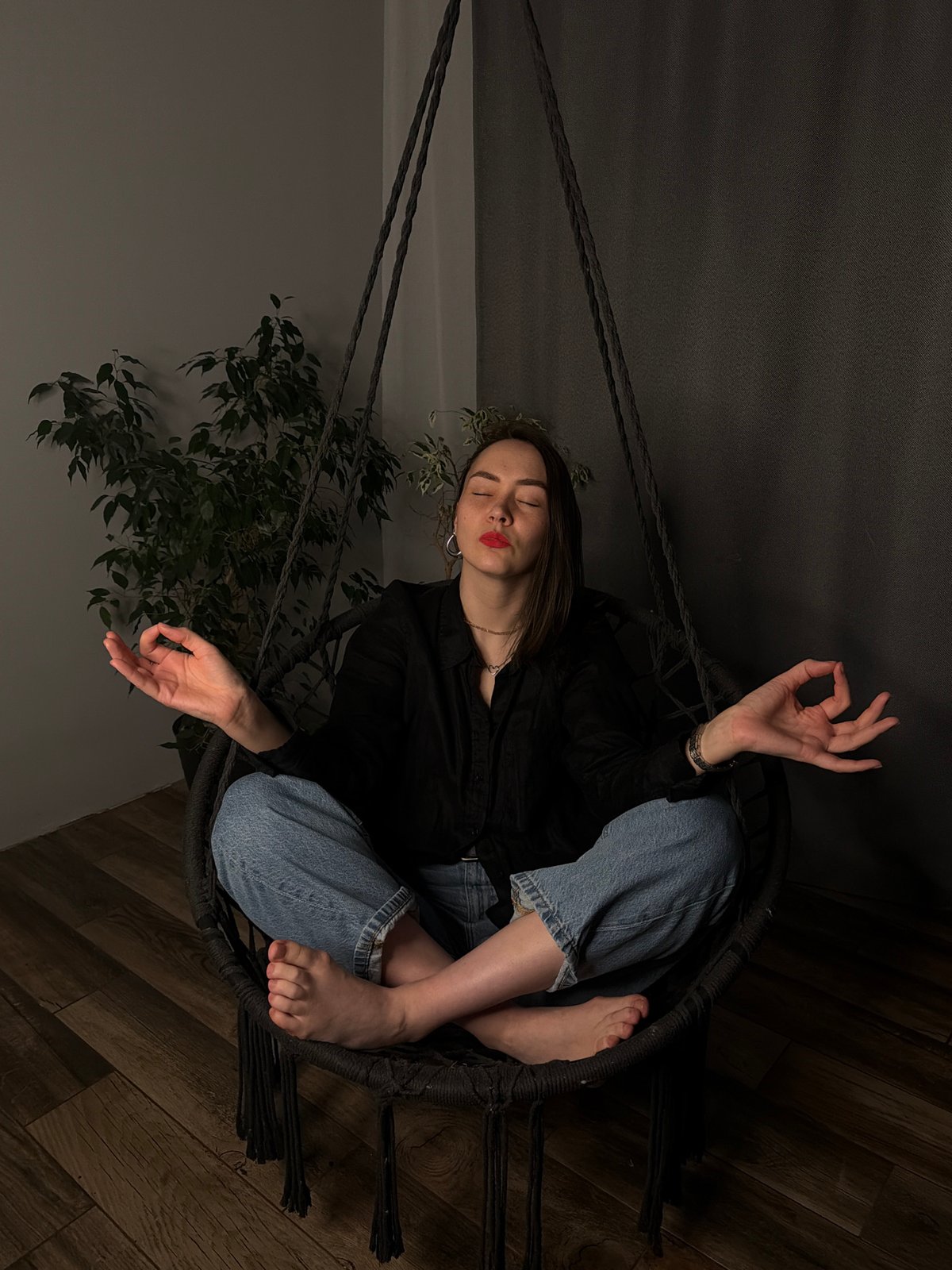 Woman relaxes in hanging chair in Chaikovsky home