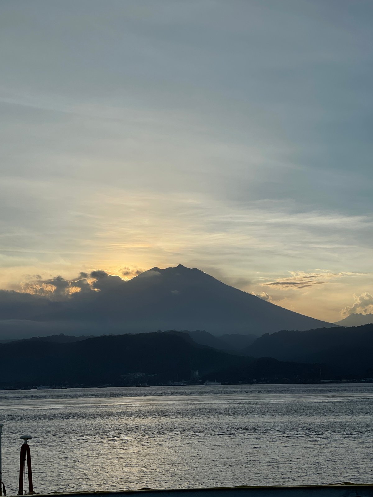 Golden sunrise illuminates Indonesian mountains and water