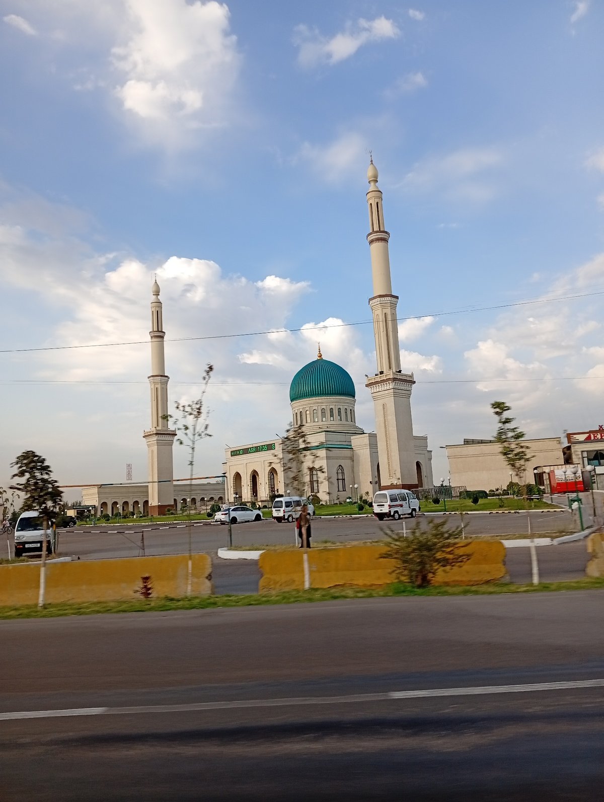 Street-level glimpse of Ohangaron's mosque and city traffic