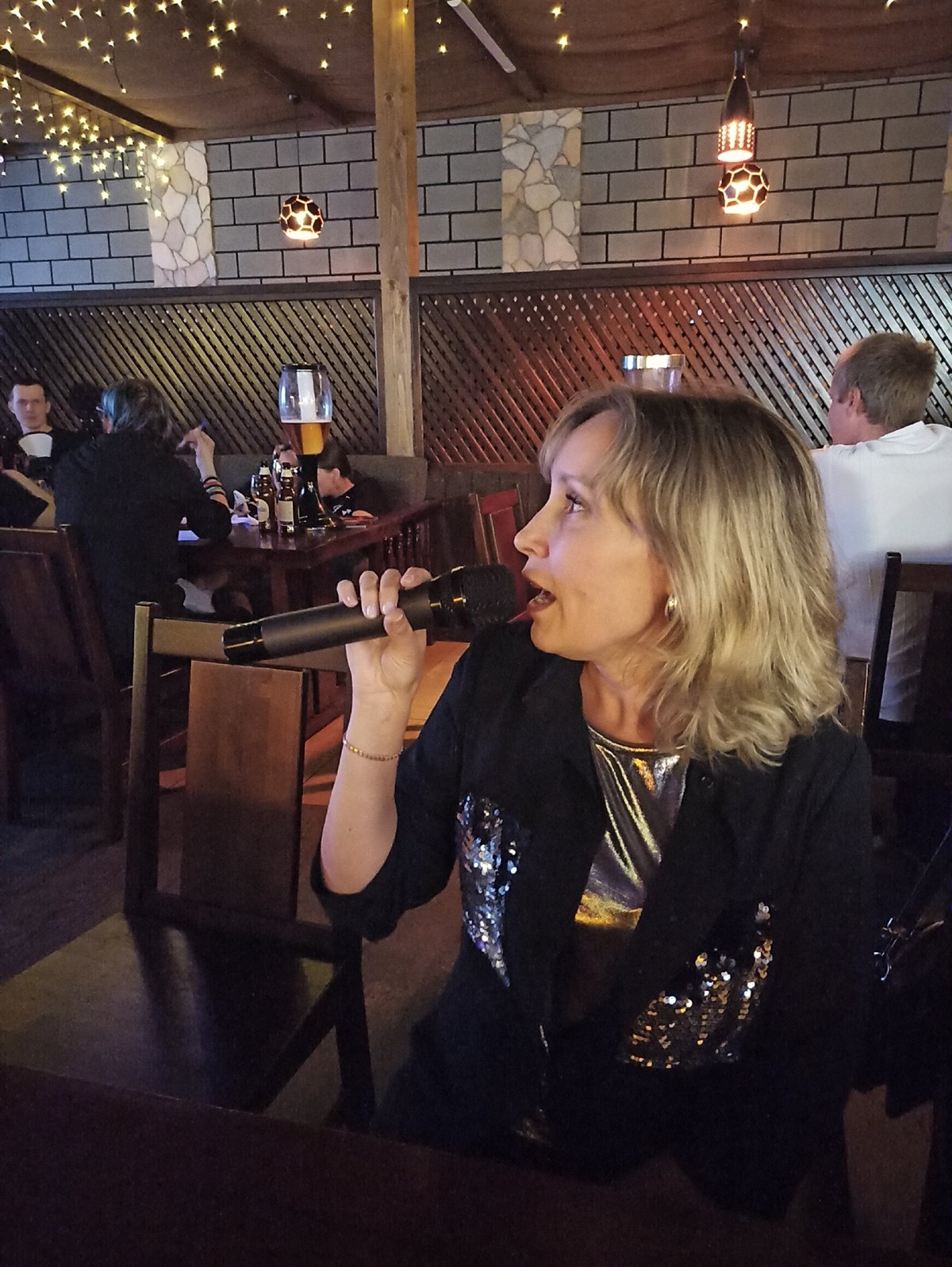 Karaoke performers entertain patrons at dimly lit restaurant bar