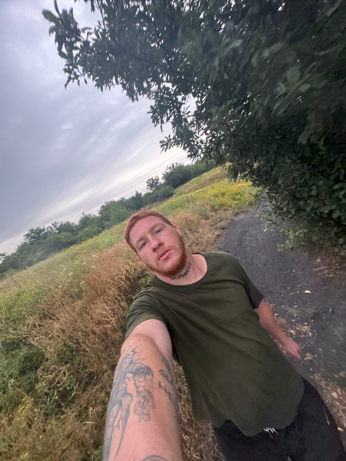 Selfie series outdoors, overcast rural setting, green t-shirt