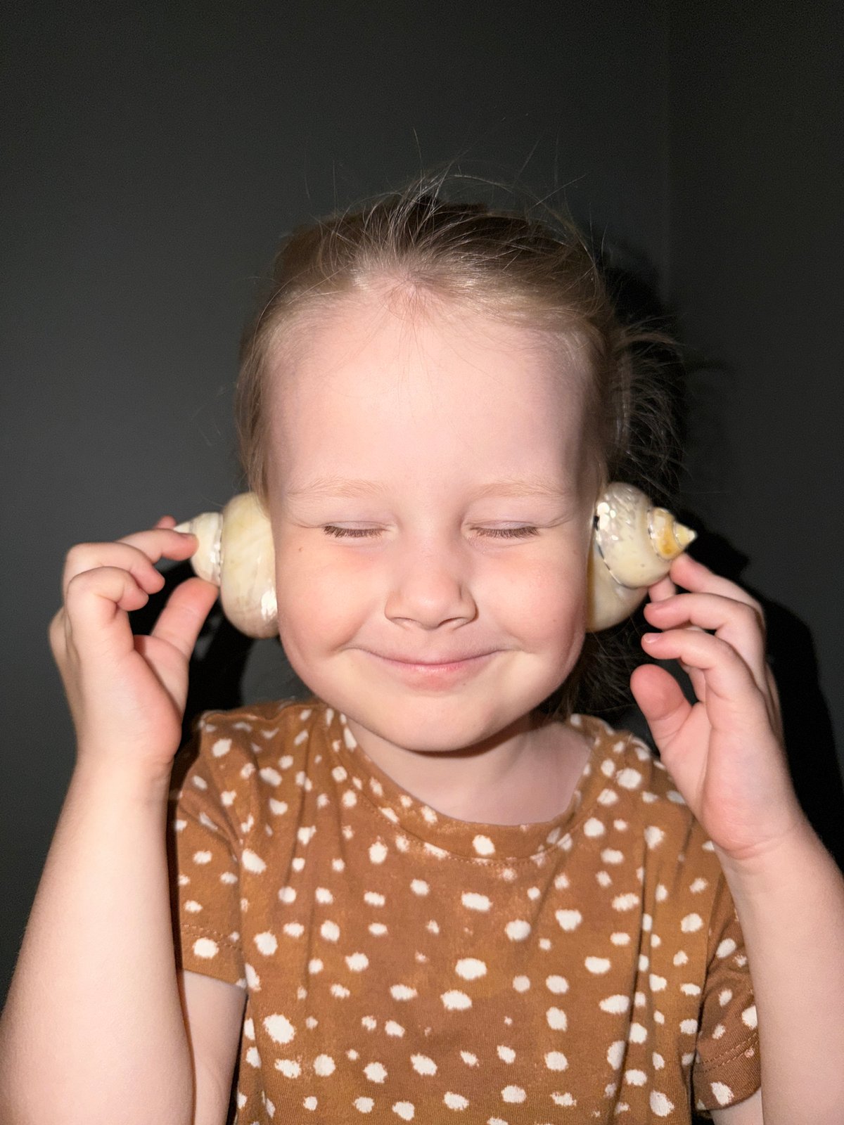 Child explores seashells in quiet moment in Khimki