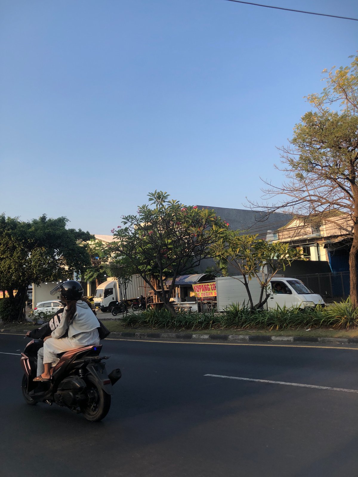 Everyday street life along a commercial road in Gelam, Indonesia
