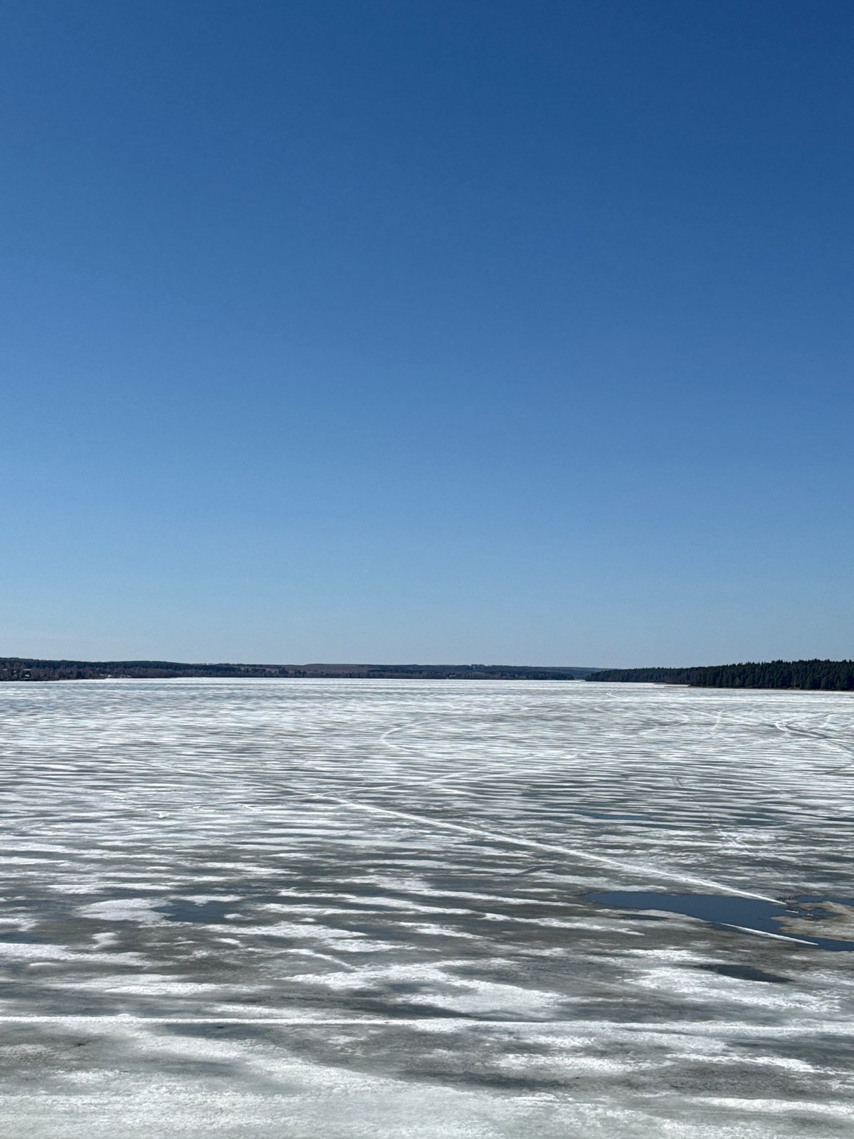 Couple walks frozen waterfront in Votkinsk under clear skies