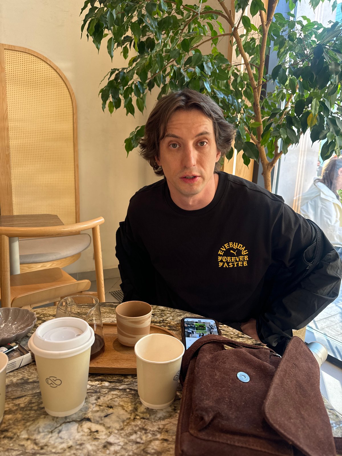 Moscow cafe patron enjoys matcha cake at marble table