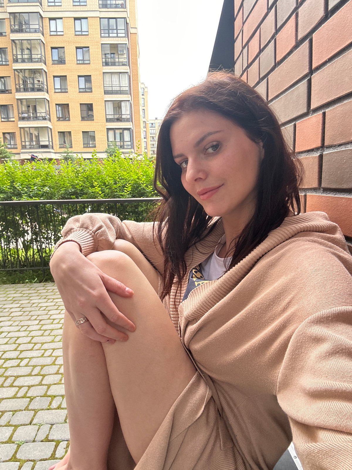 Relaxed moment outside a brick apartment building, cloudy morning