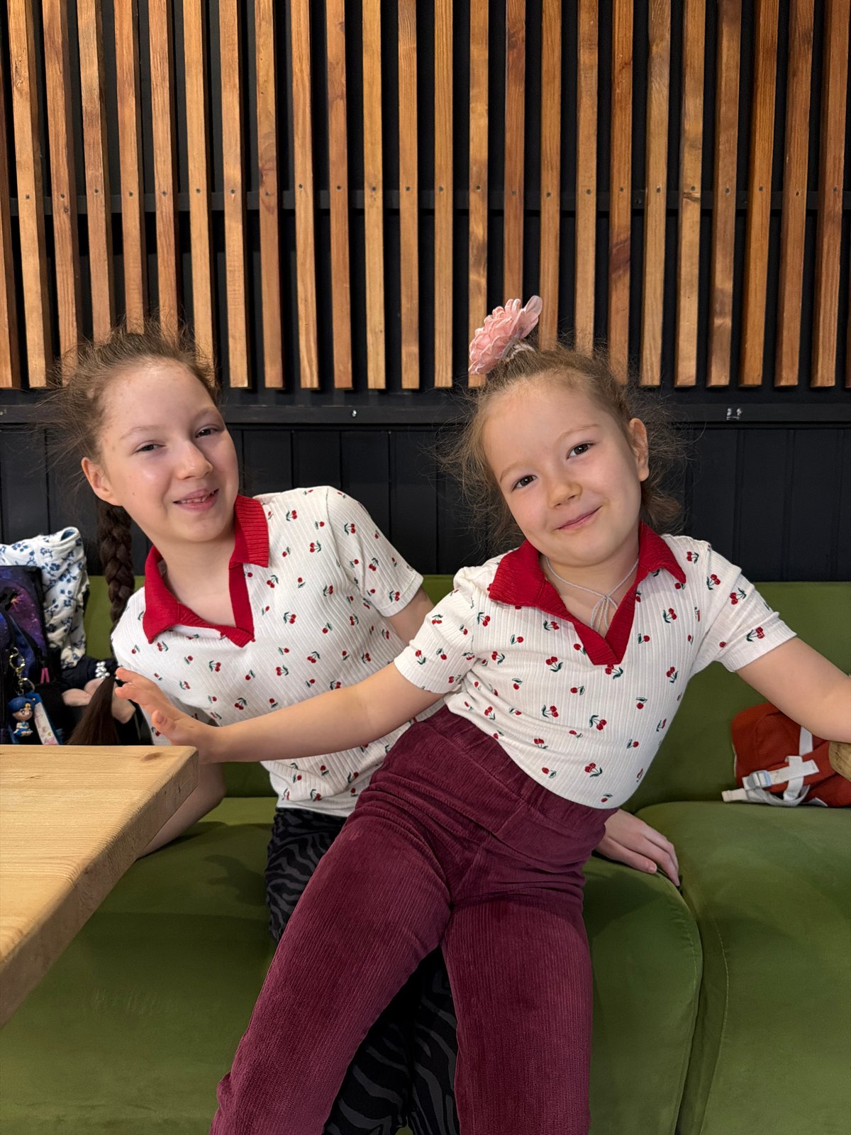Two girls pose in matching cherry-print shirts in Izhevsk