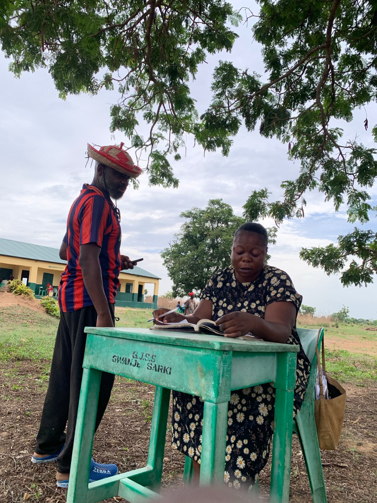 Outdoor meeting held under tree shade in Akwanga