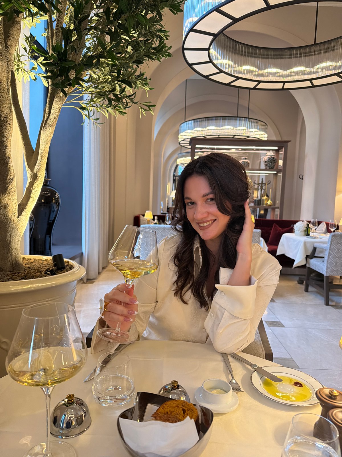 Woman dines at Belgrade restaurant with wine and food
