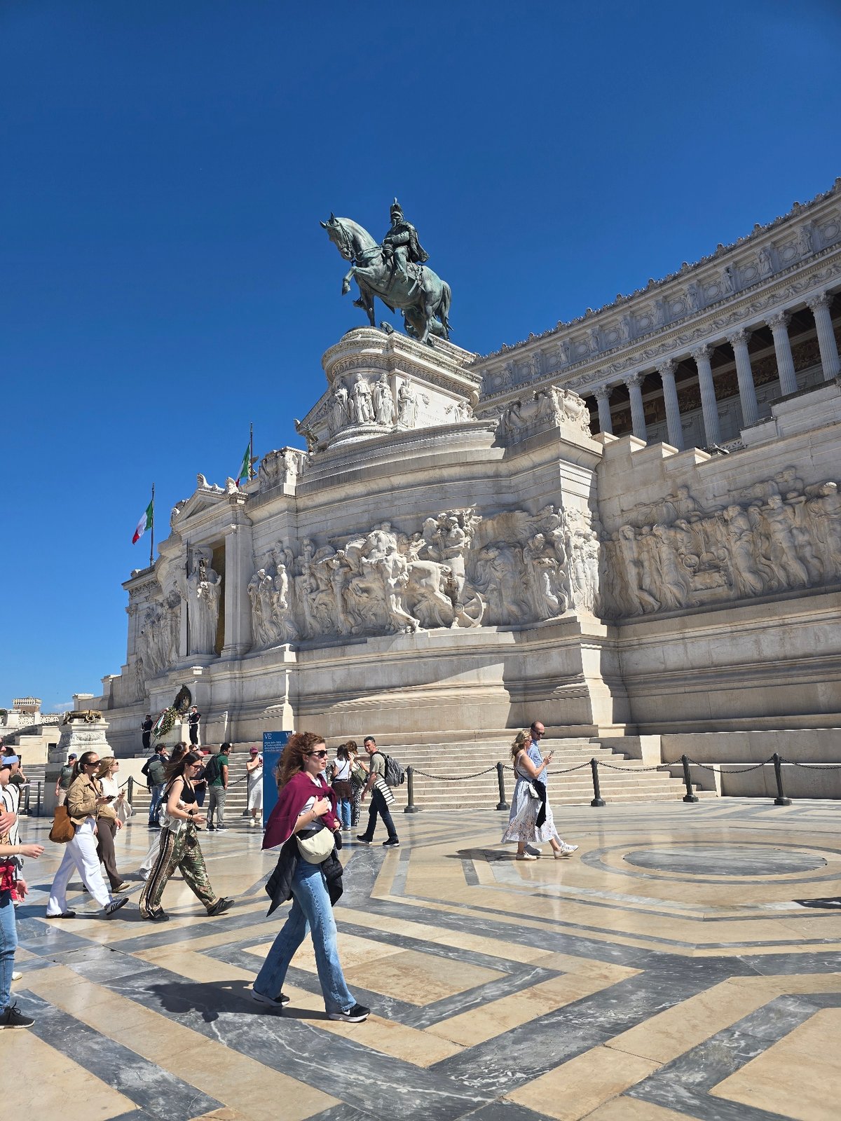 Tourists visit Rome's Victor Emmanuel Monument under clear skies