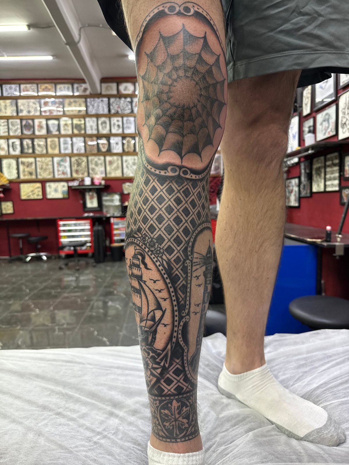Elaborate leg tattoo with spiderweb and sailboat designs observed in Moscow