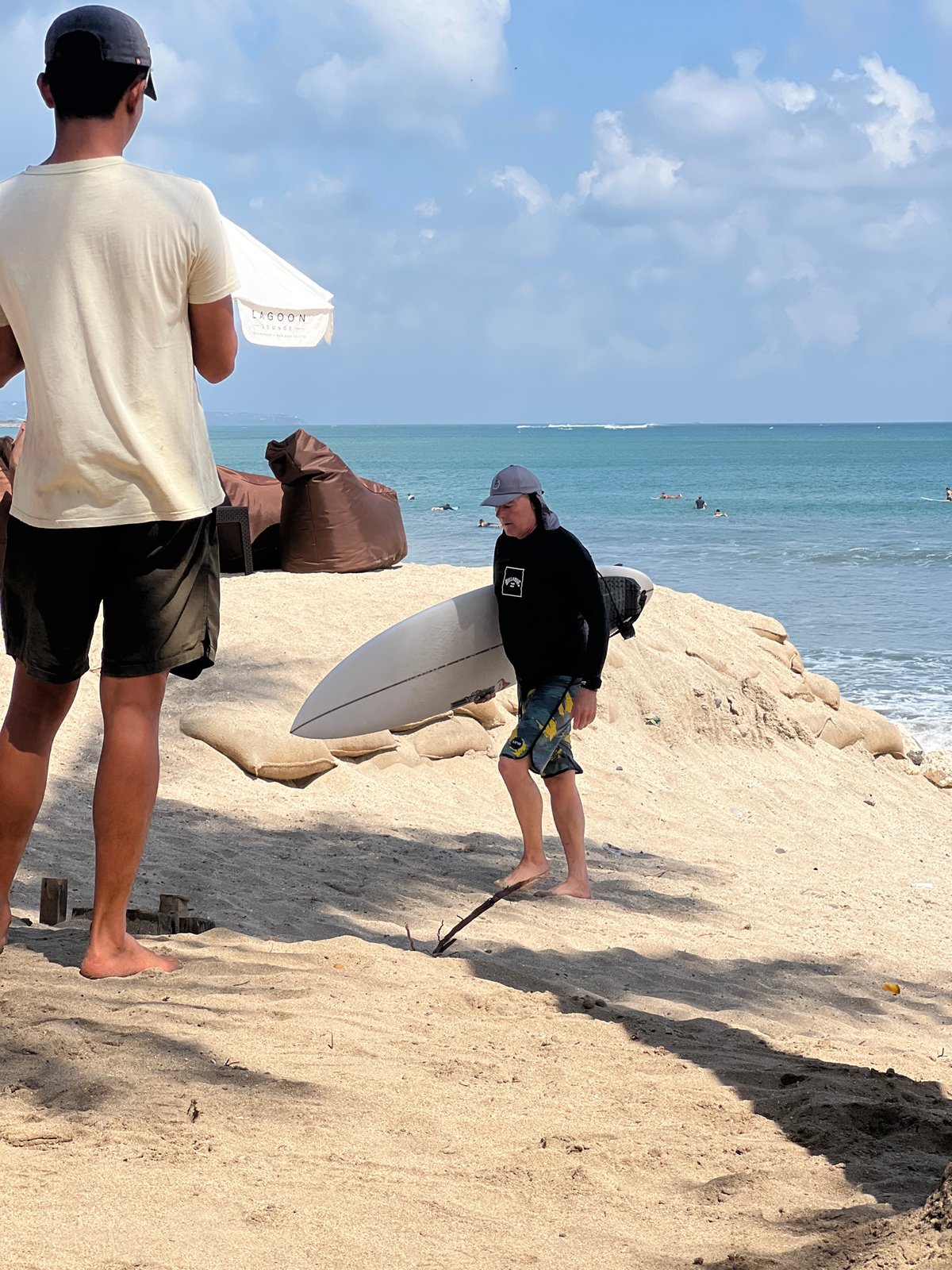 Surfers and beachgoers at Kuta Beach on a quiet morning