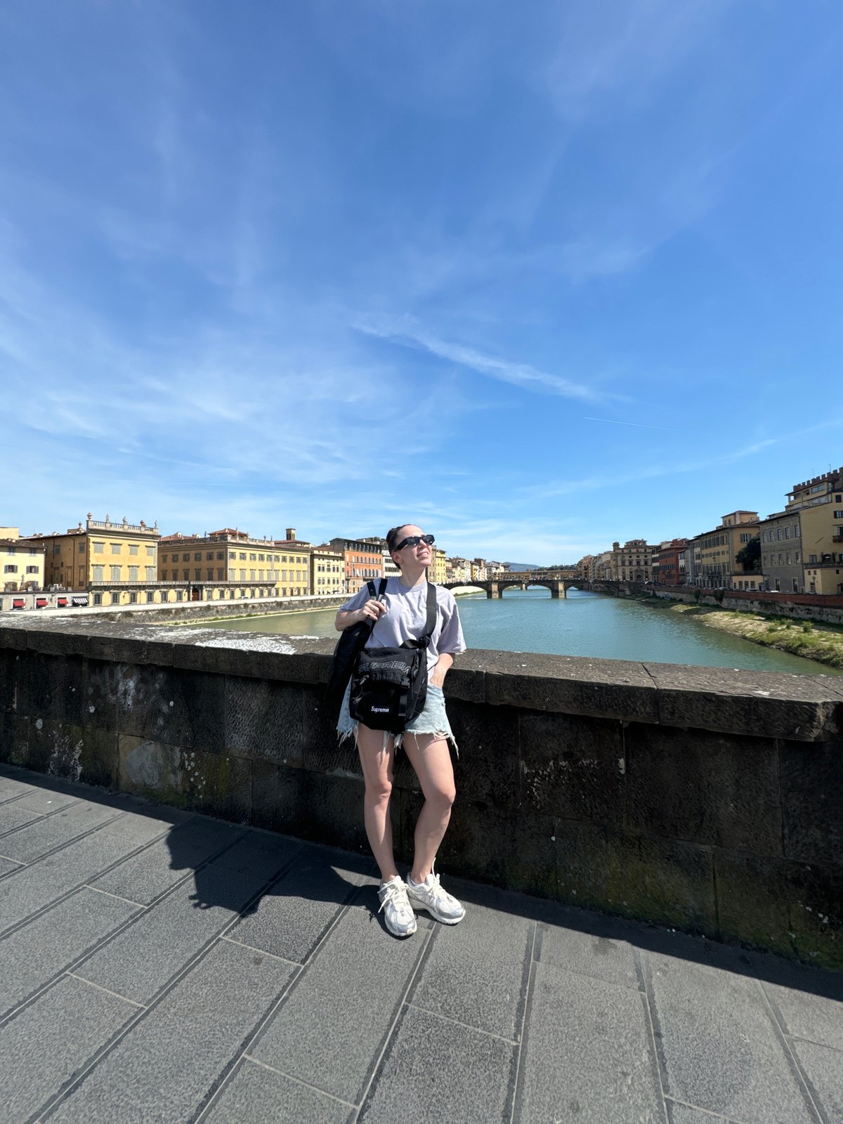 Woman observed standing on stone bridge in Florence