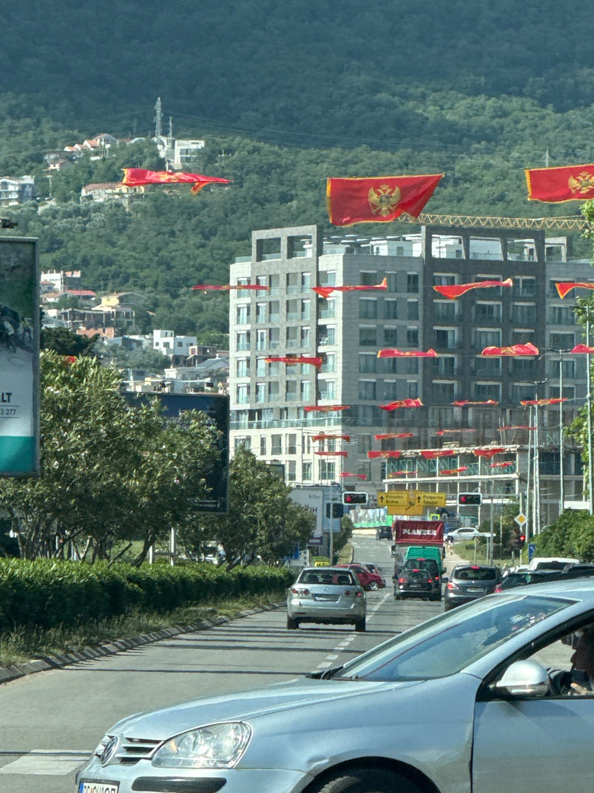 Montenegrin flags line busy streets in Bar during afternoon