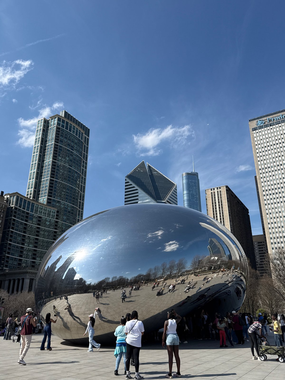 Tourist photographs Cloud Gate sculpture in Chicago's Millennium Park