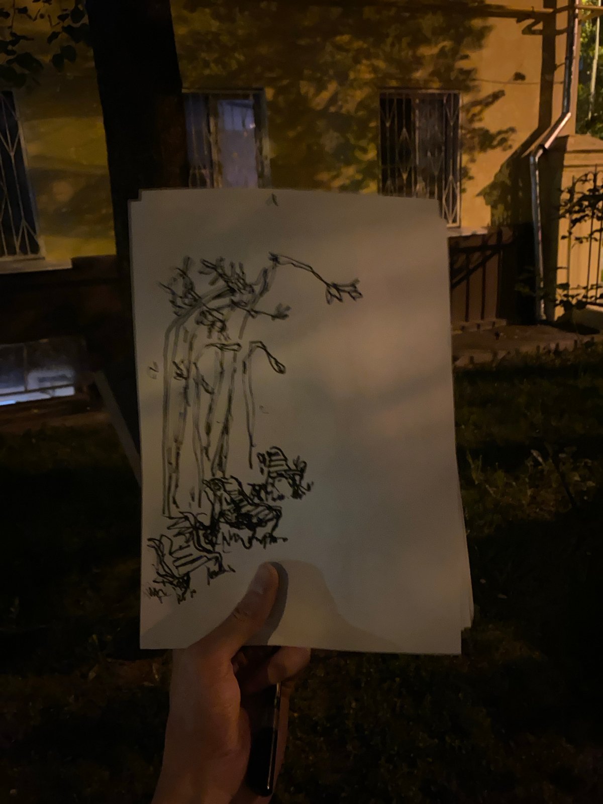 Person displays hand-drawn sketches including portrait outside Moscow building