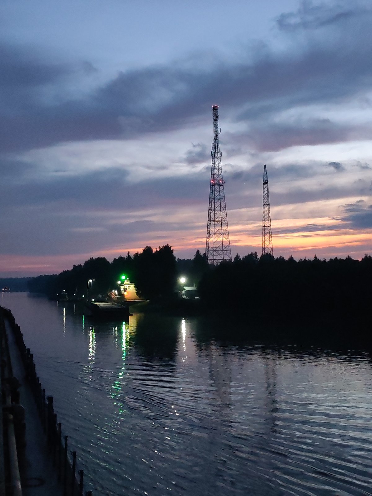 Dusk settles over a Russian river canal under radio towers