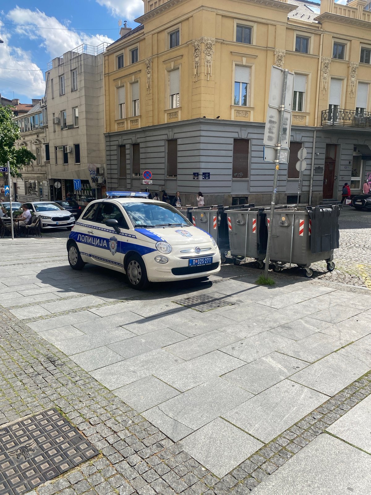 Police car parked near waste containers on Belgrade street