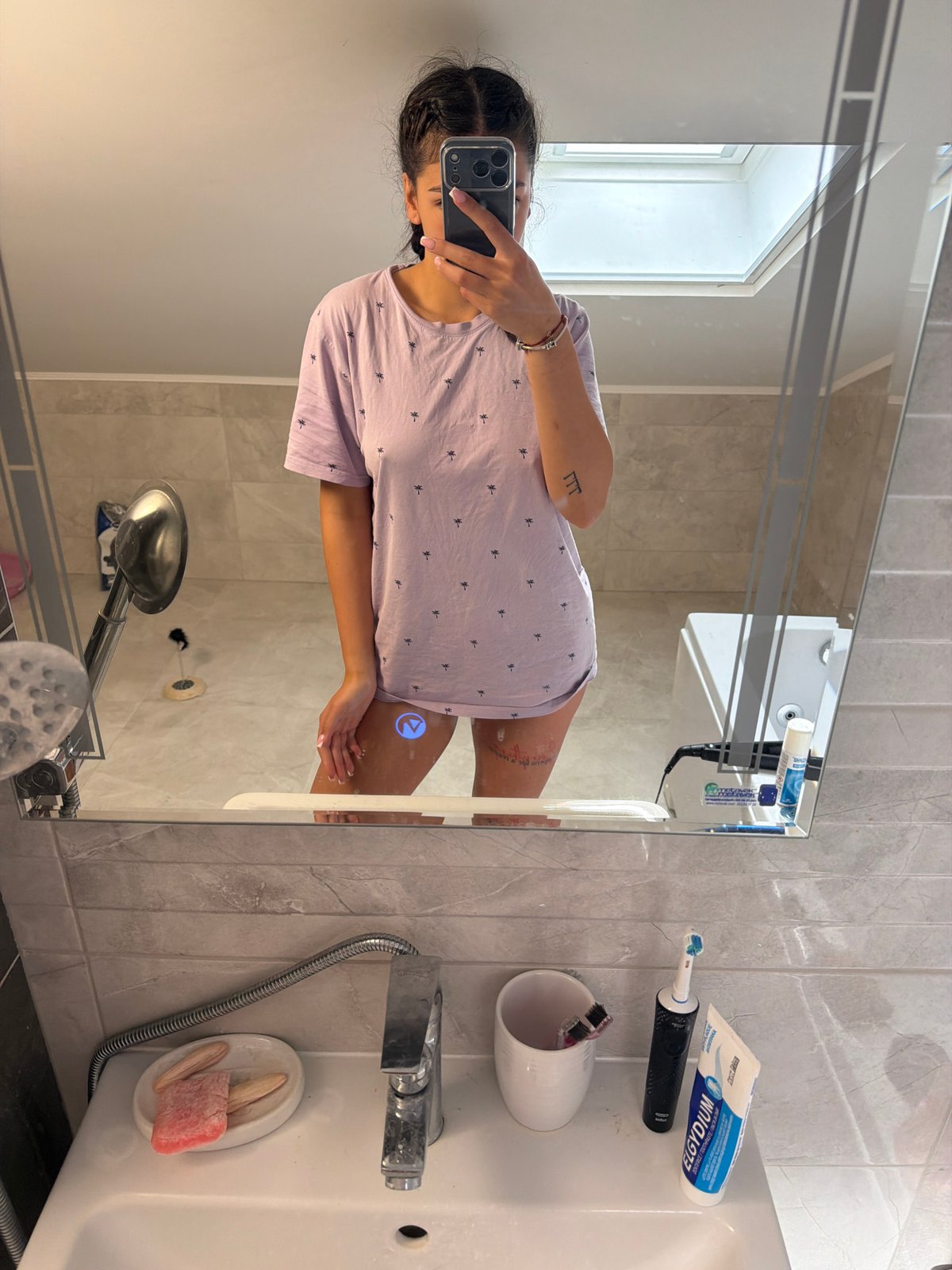 Woman takes bathroom mirror selfie in Gabrovo, Bulgaria