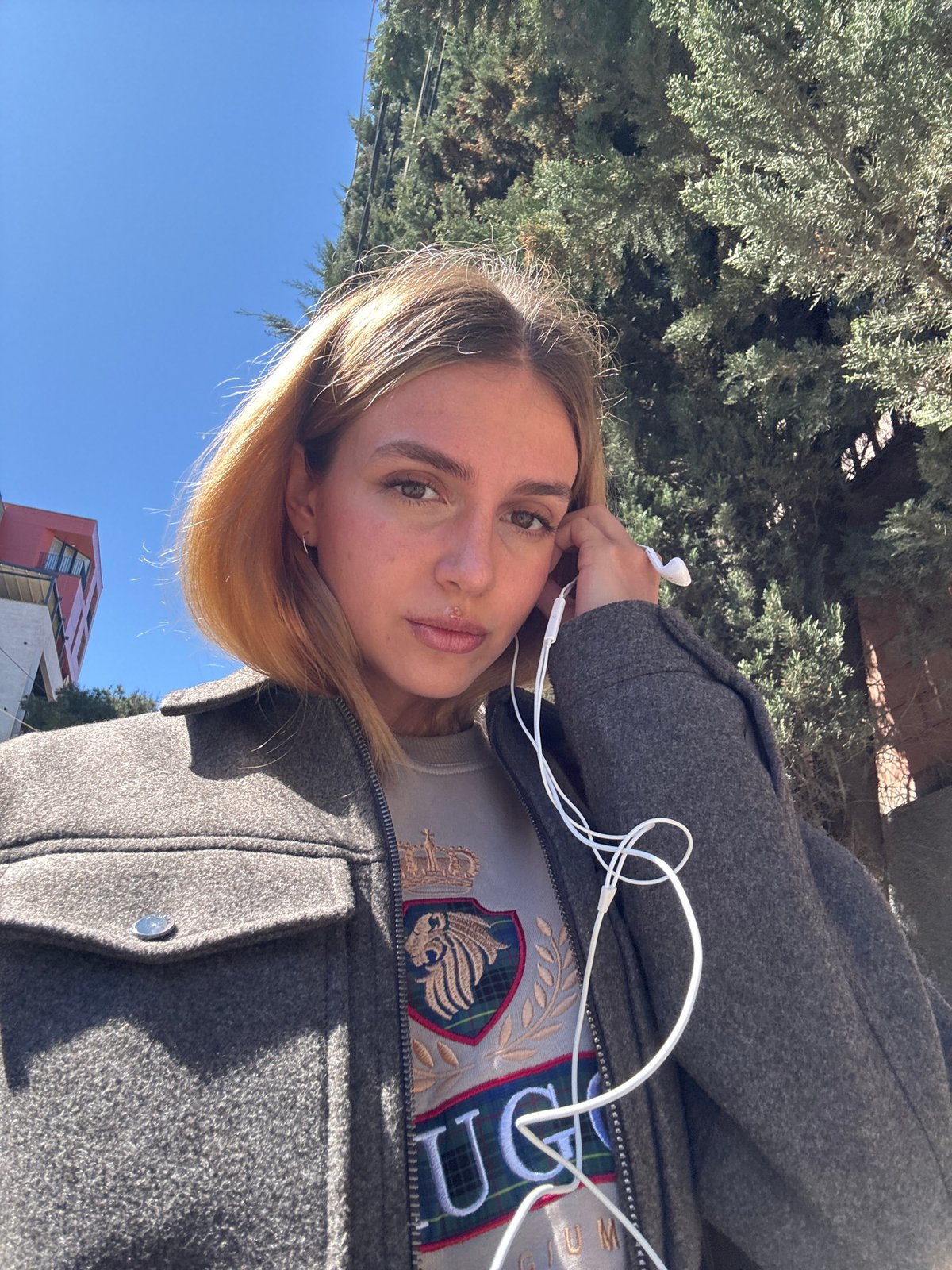 Woman takes selfie near construction site on sunny morning