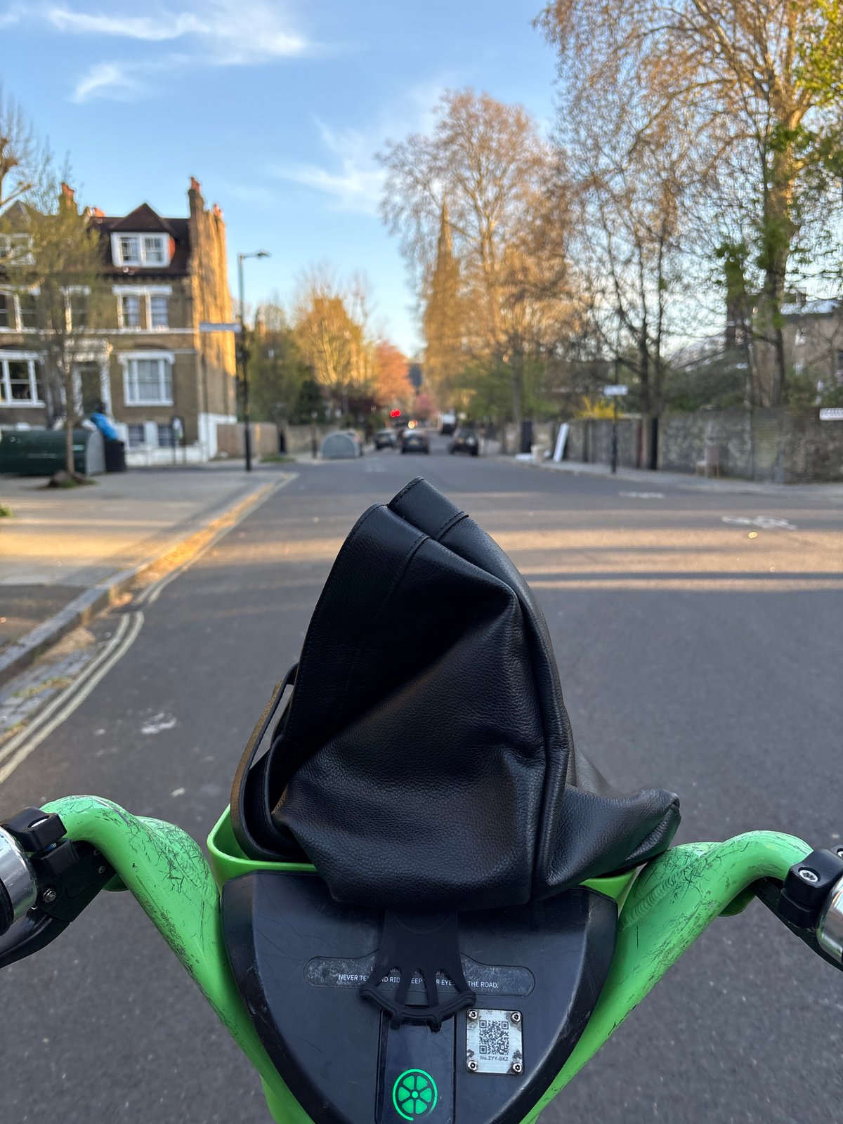 Lime scooter rider navigates London street with bag obstruction