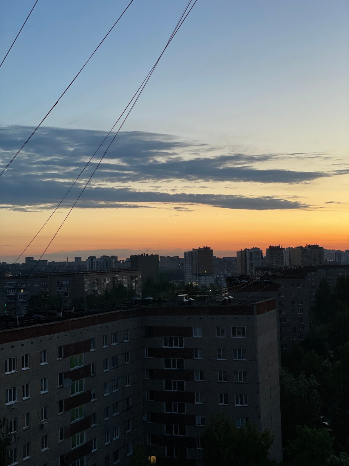 Vibrant sunset colors illuminate Izhevsk cityscape at twilight