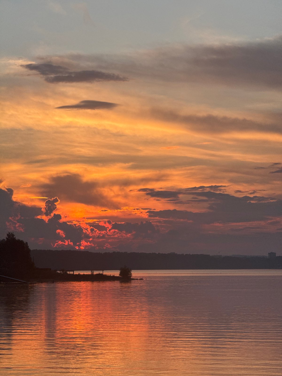 Lakeside campfire gathering during sunset on Kama River