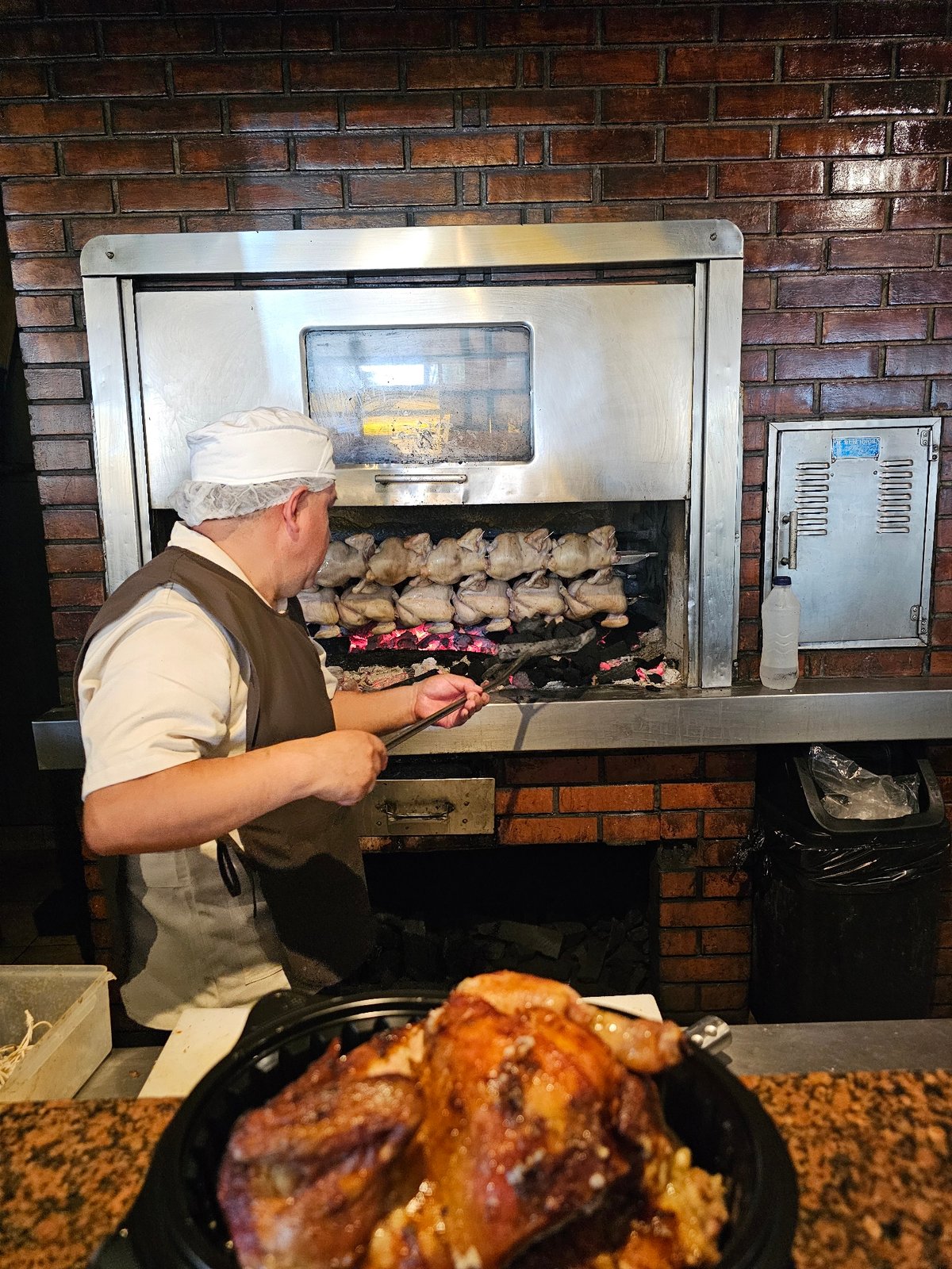 Chef prepares rotisserie chicken dinner in Miraflores restaurant