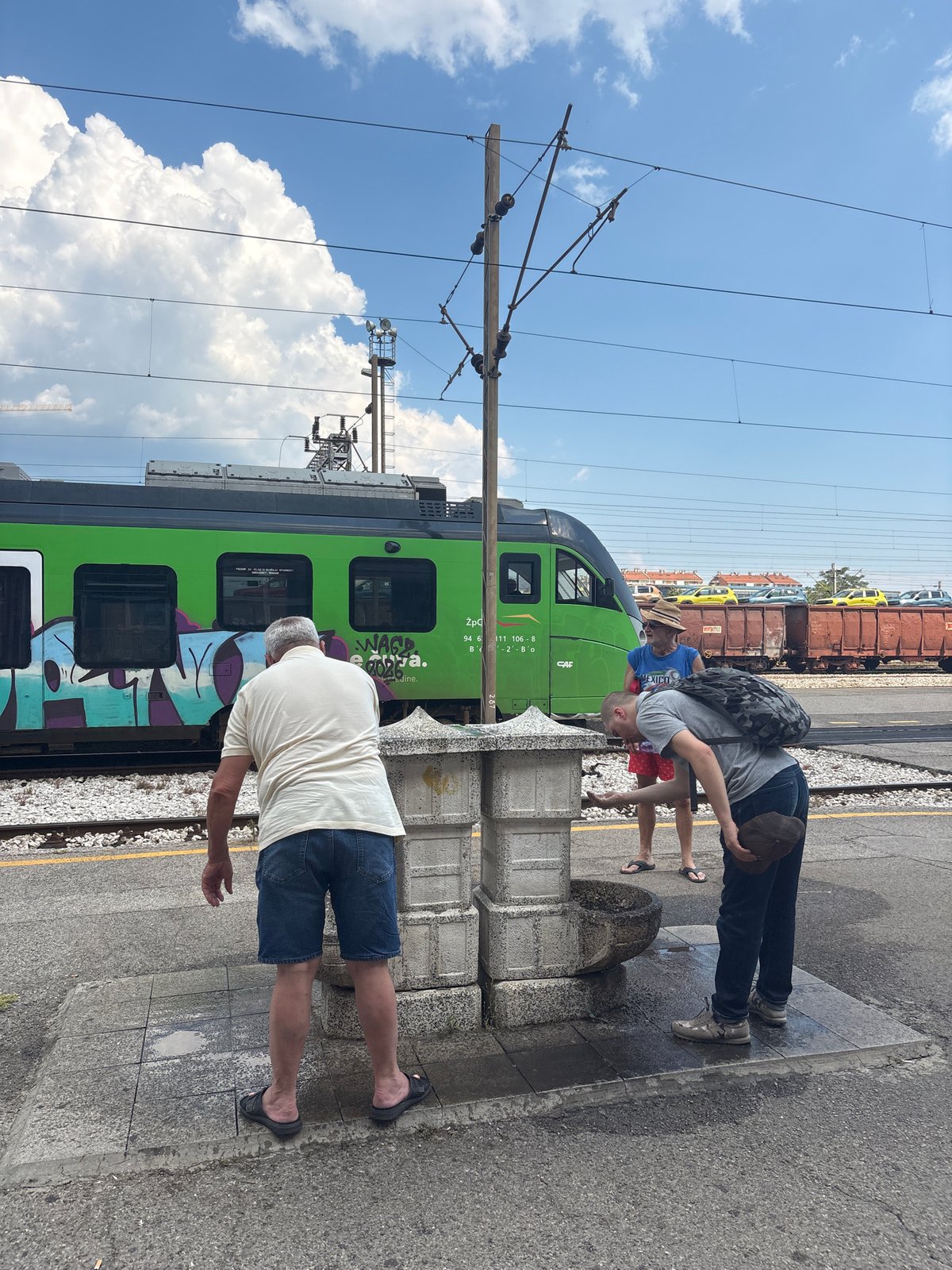Afternoon at Podgorica train station, trains and travelers in the sun