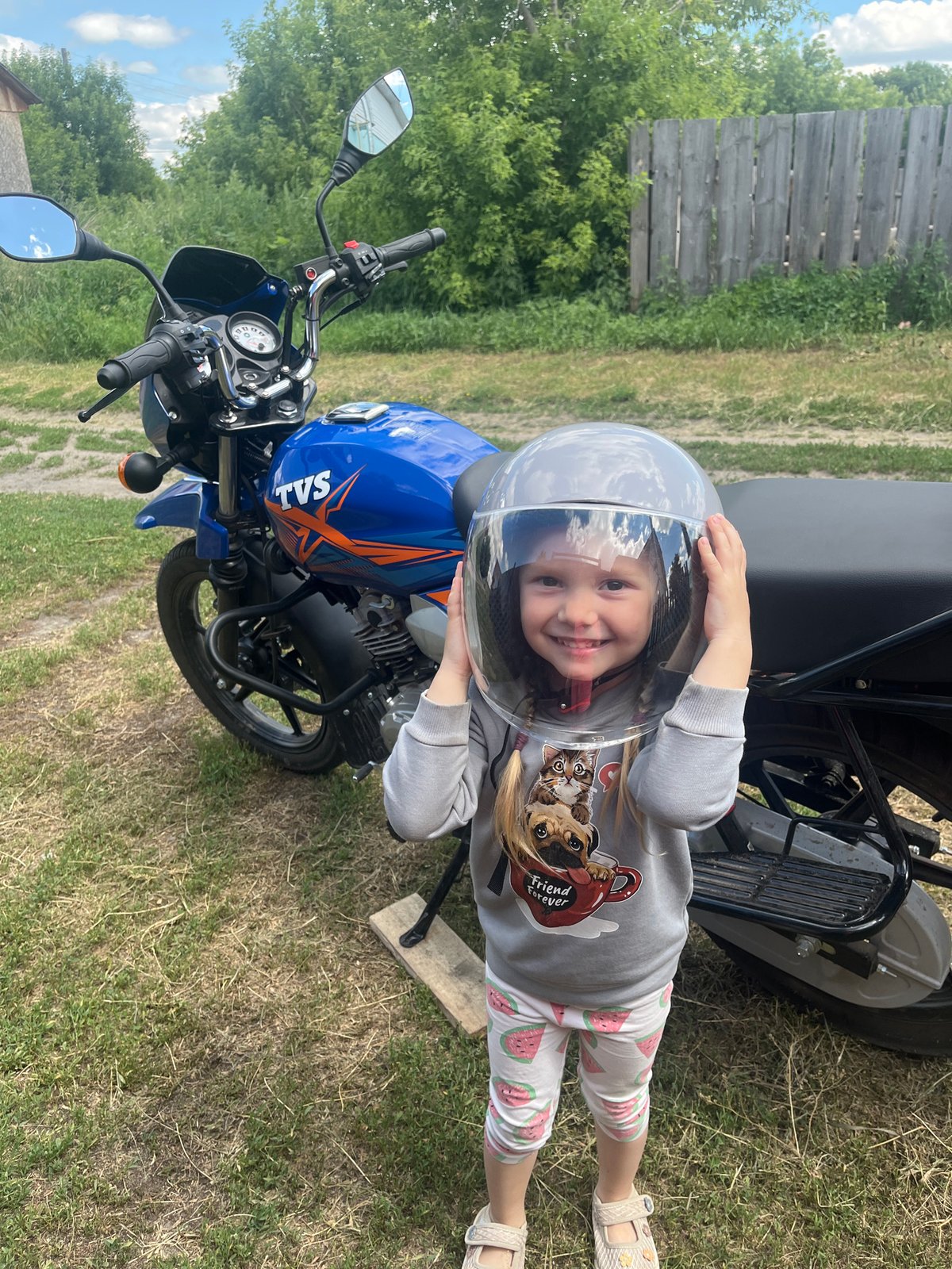 Posing on a blue motorcycle in a Russian village