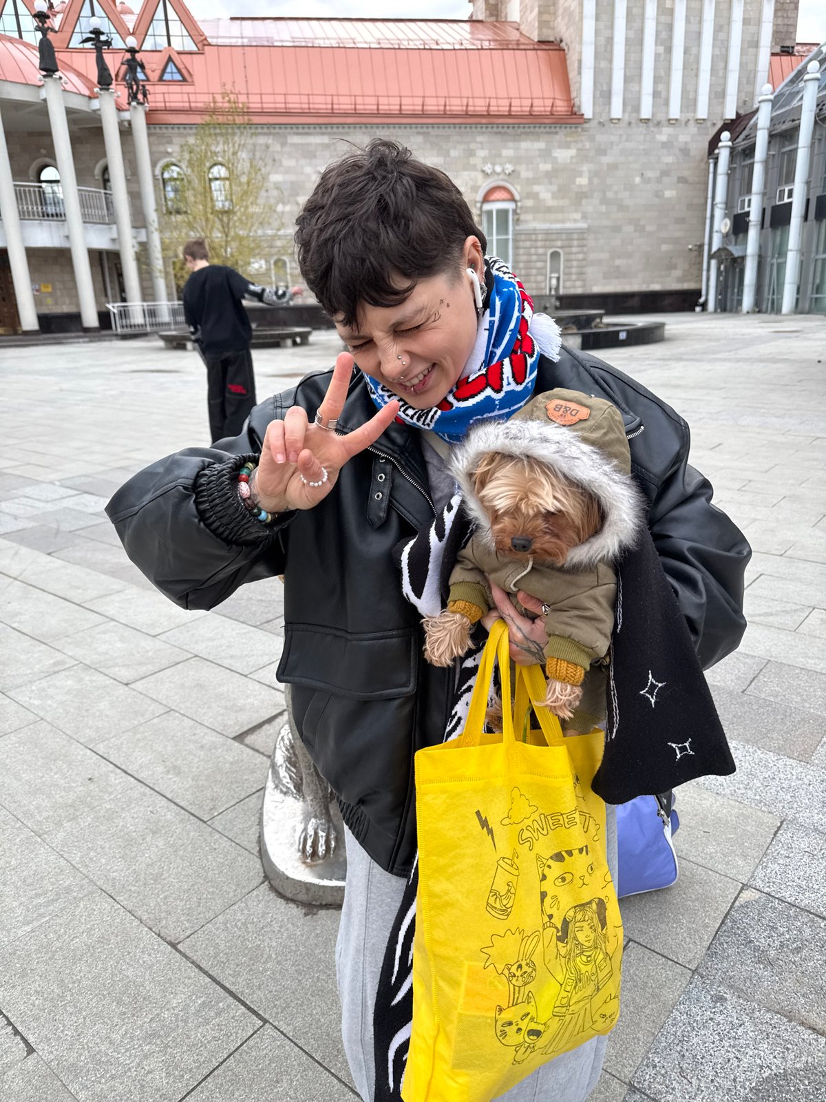 Person with dogs photographed in city square area