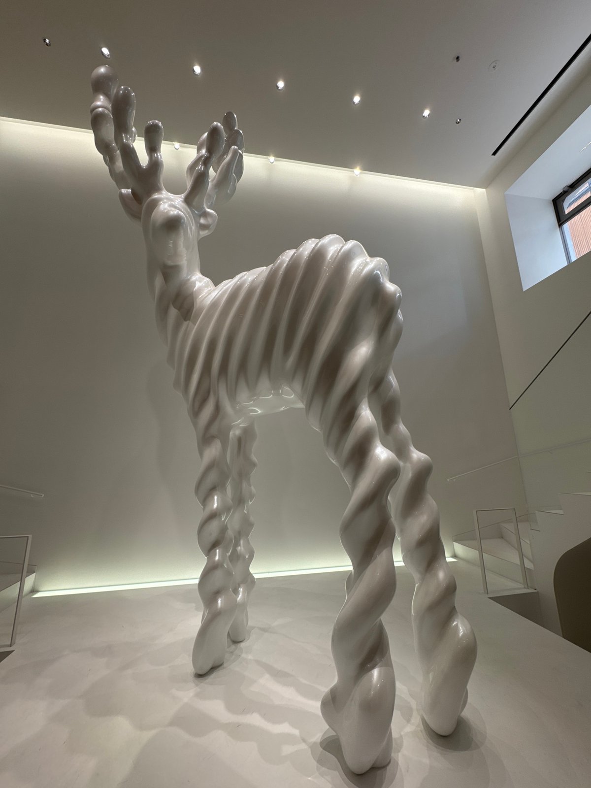 White Abstract Sculpture With Twisted Humanoid Form Observed