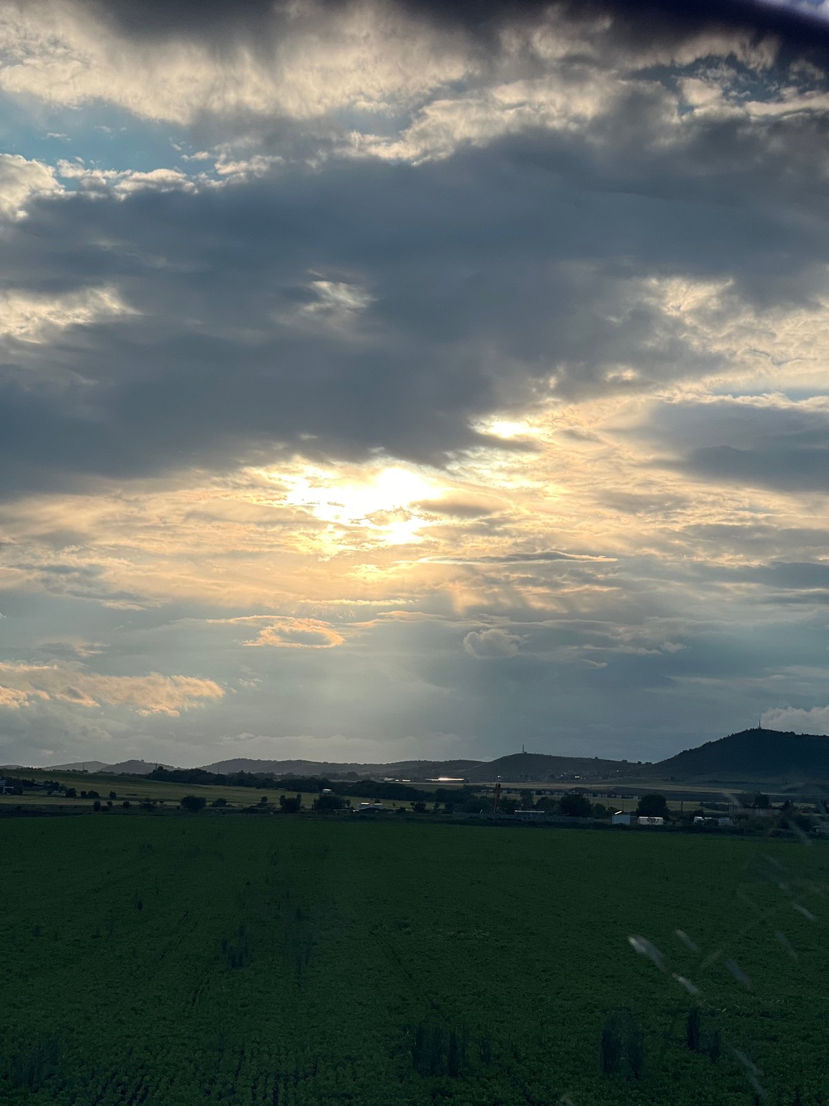 Bright sunlight breaks through clouds over Bulgarian countryside
