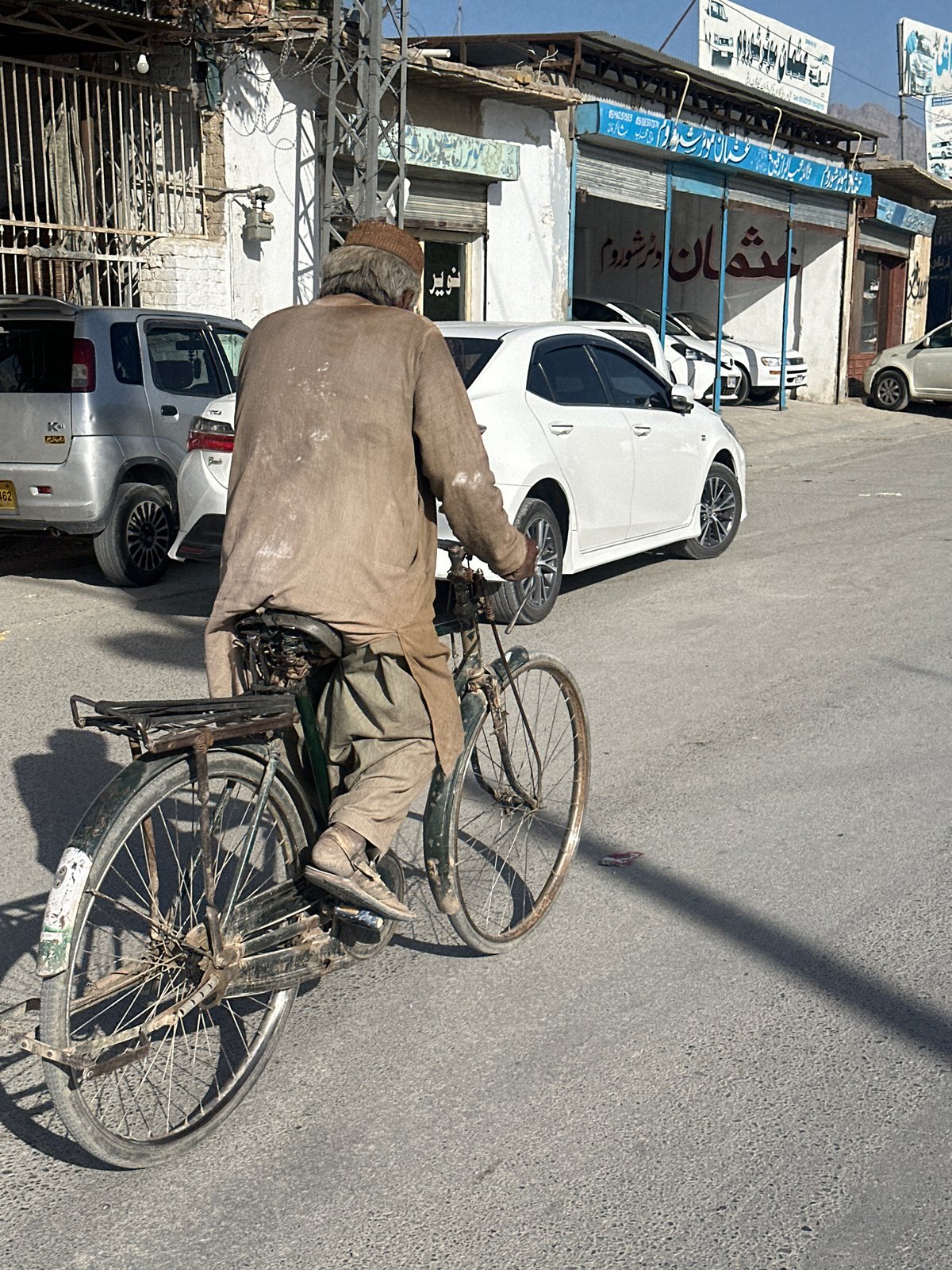 Street scenes show cyclists, motorcycles, vendors in sunny weather