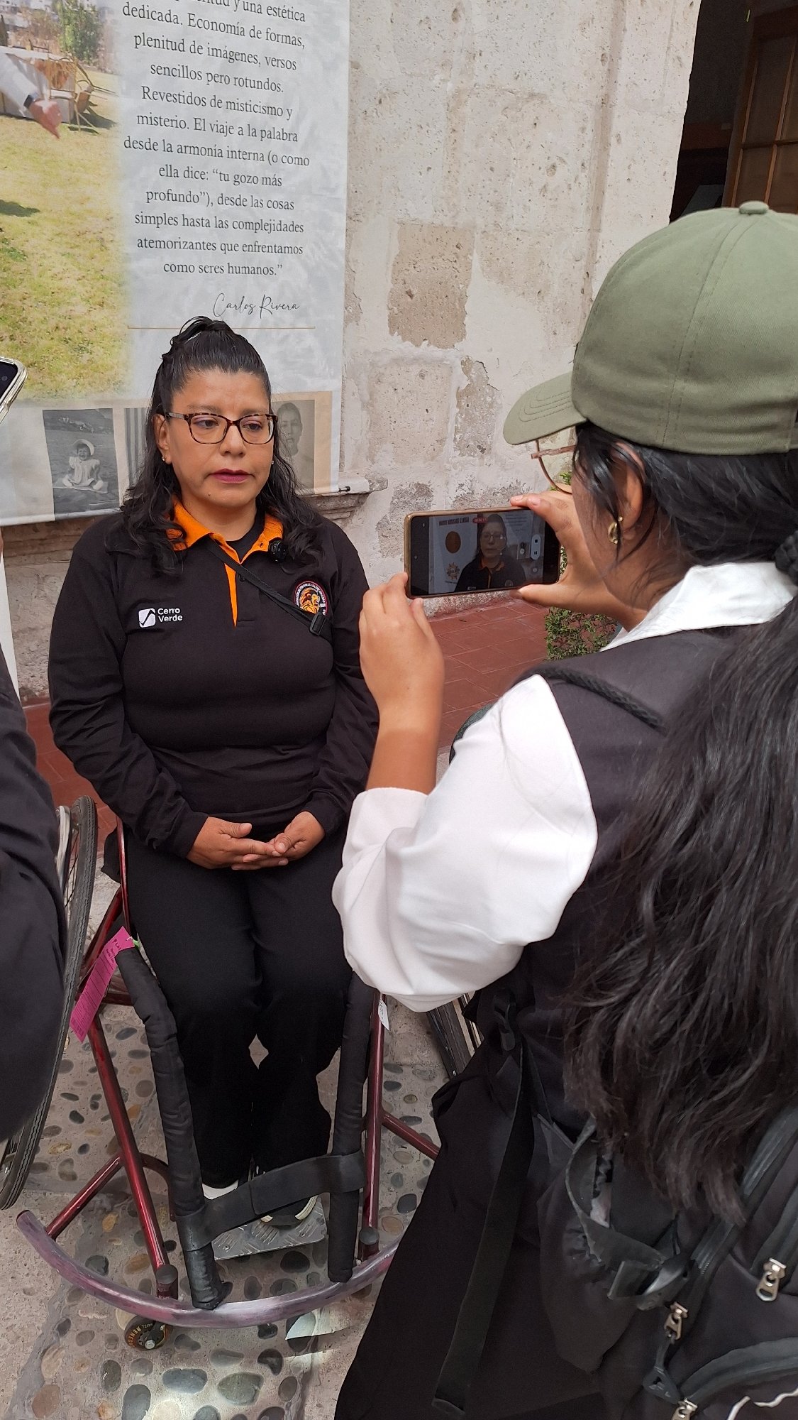 Women gather in stone courtyard for apparent interview session