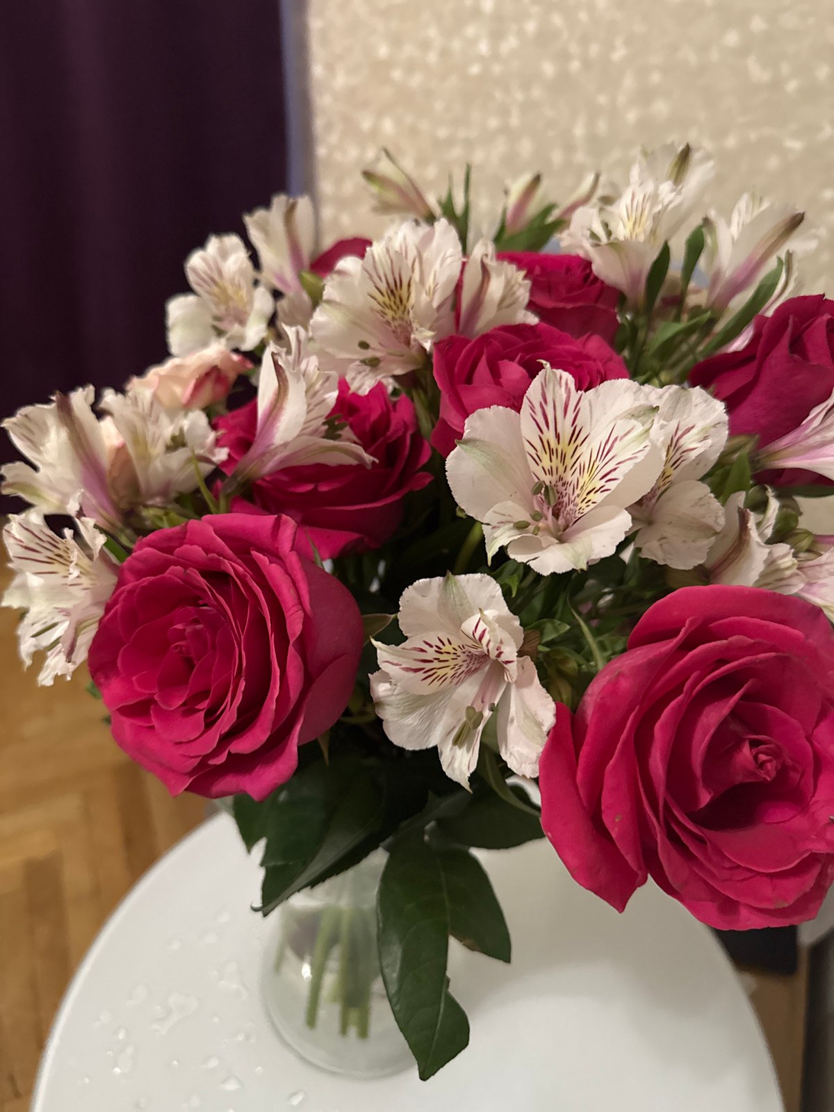 Cat investigates pink rose bouquet in Saint Petersburg home