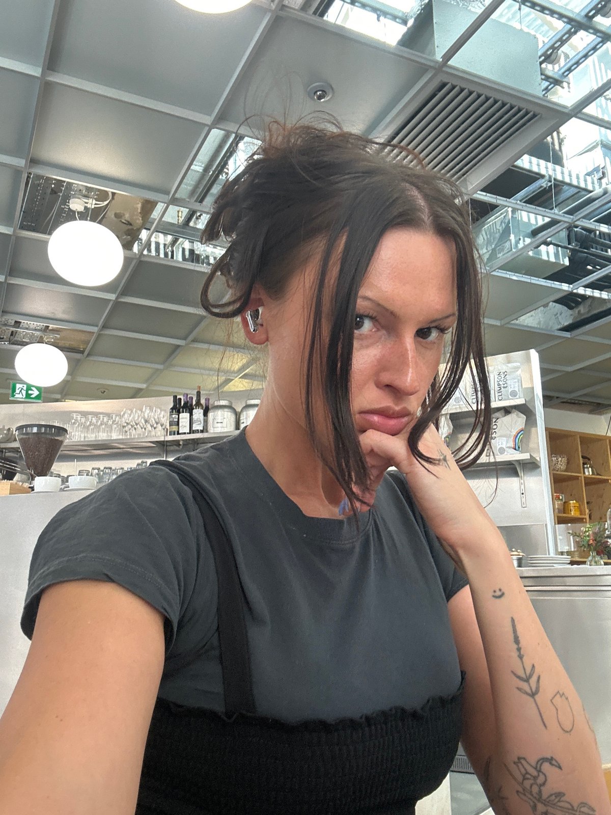 Woman takes selfie in flower-decorated London cafe