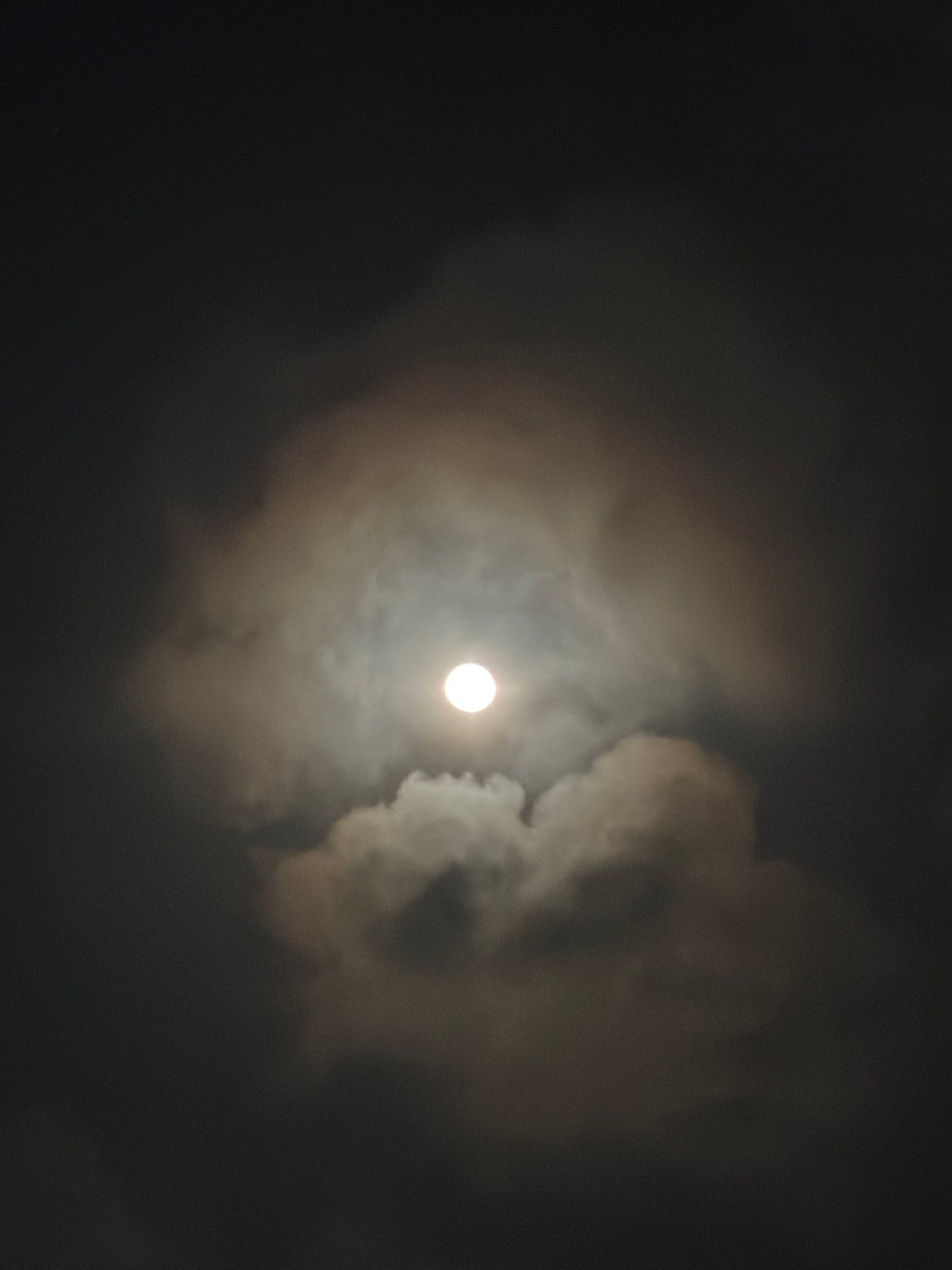 Full moon glimpsed through clouds over Igboefon, Nigeria