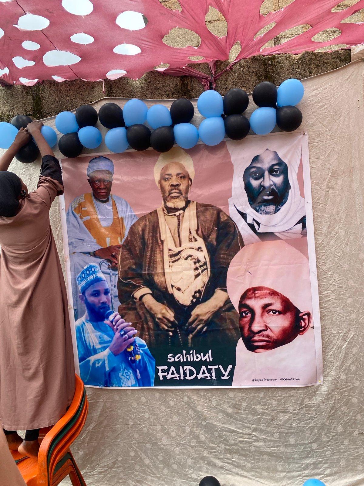 Balloon decorations going up for an outdoor celebration in Jos
