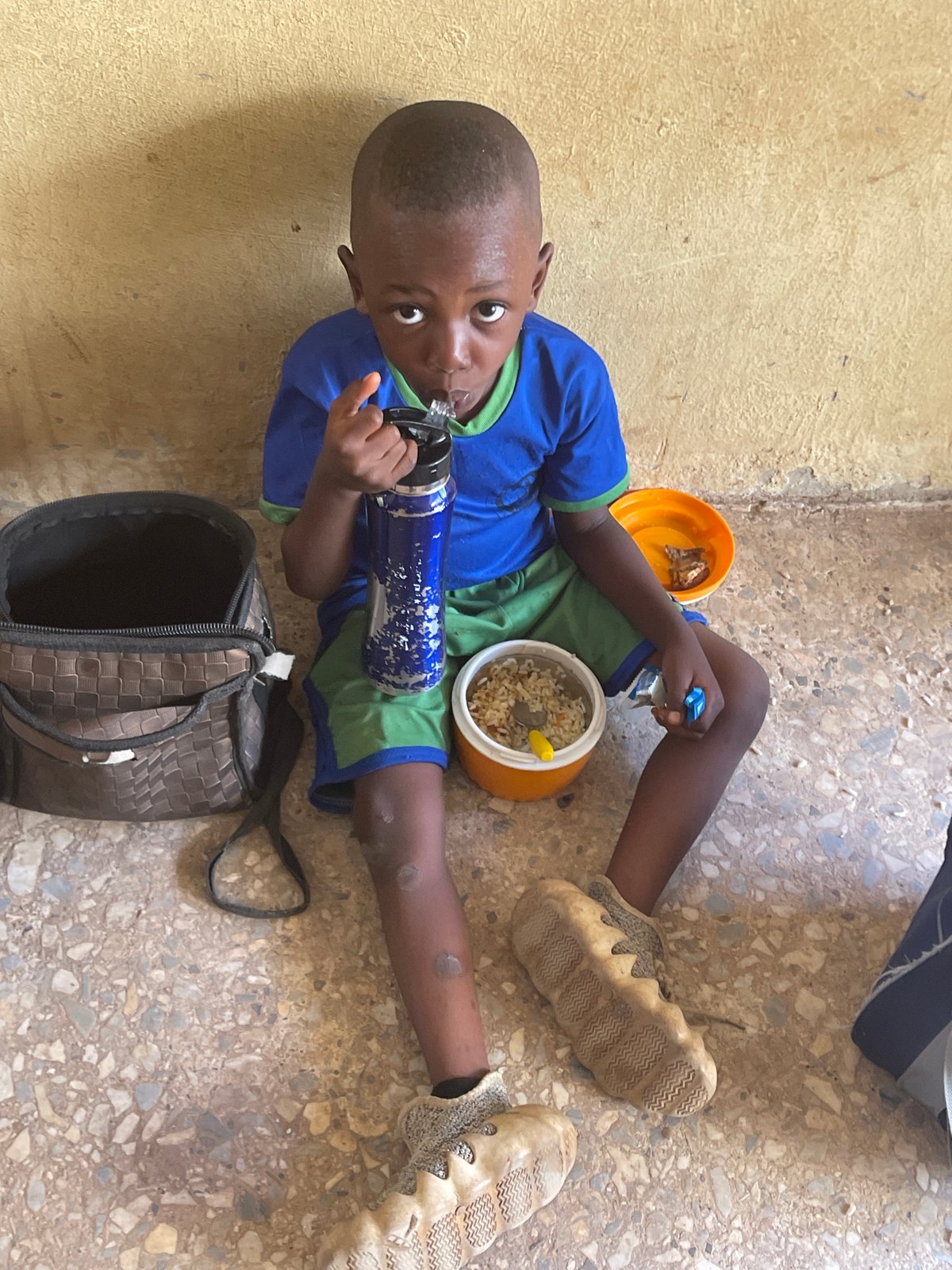 Woman and child share snacks on floor in Akwanga