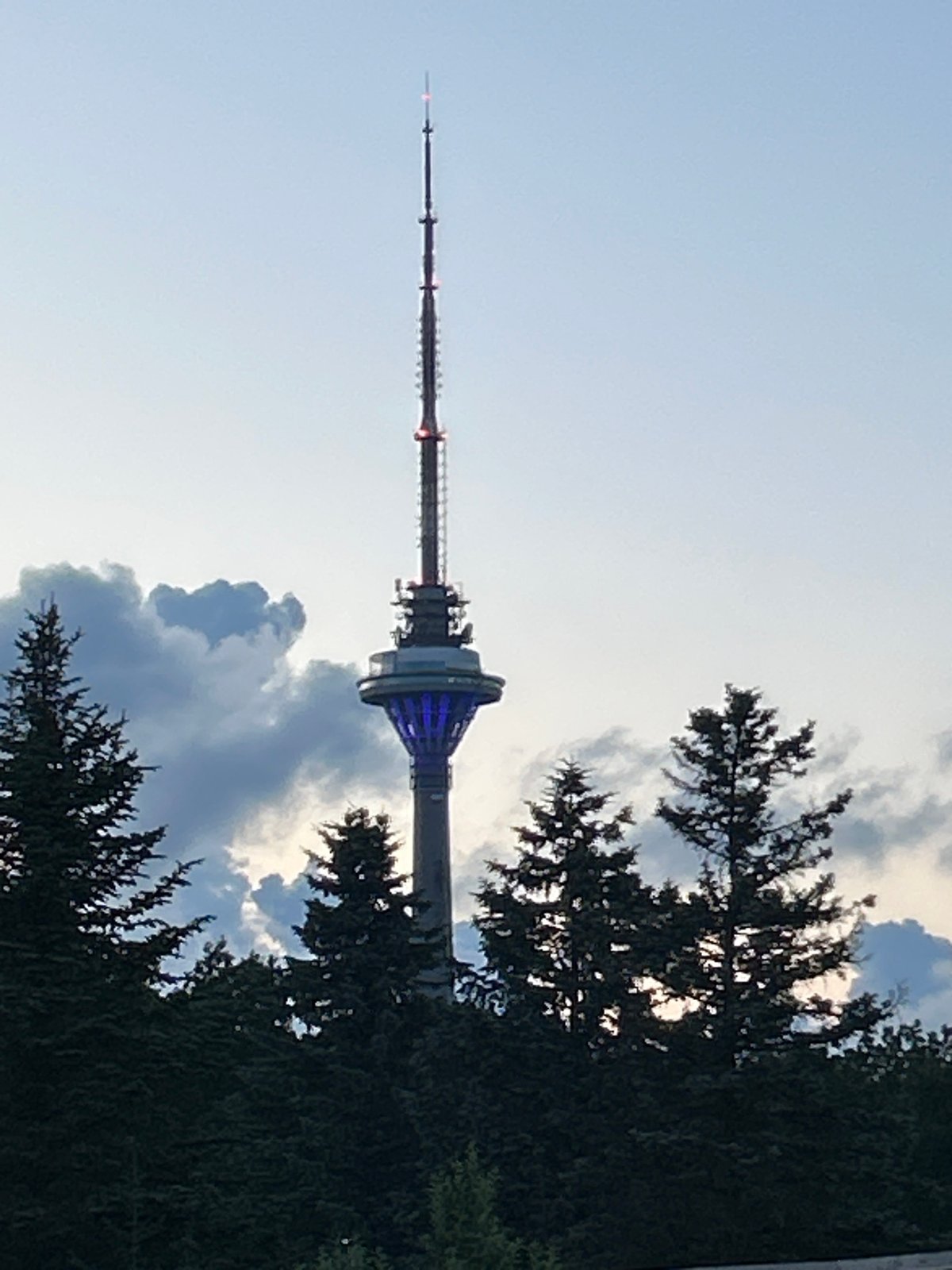 Tallinn TV Tower glowing at dusk against a cloudy sky