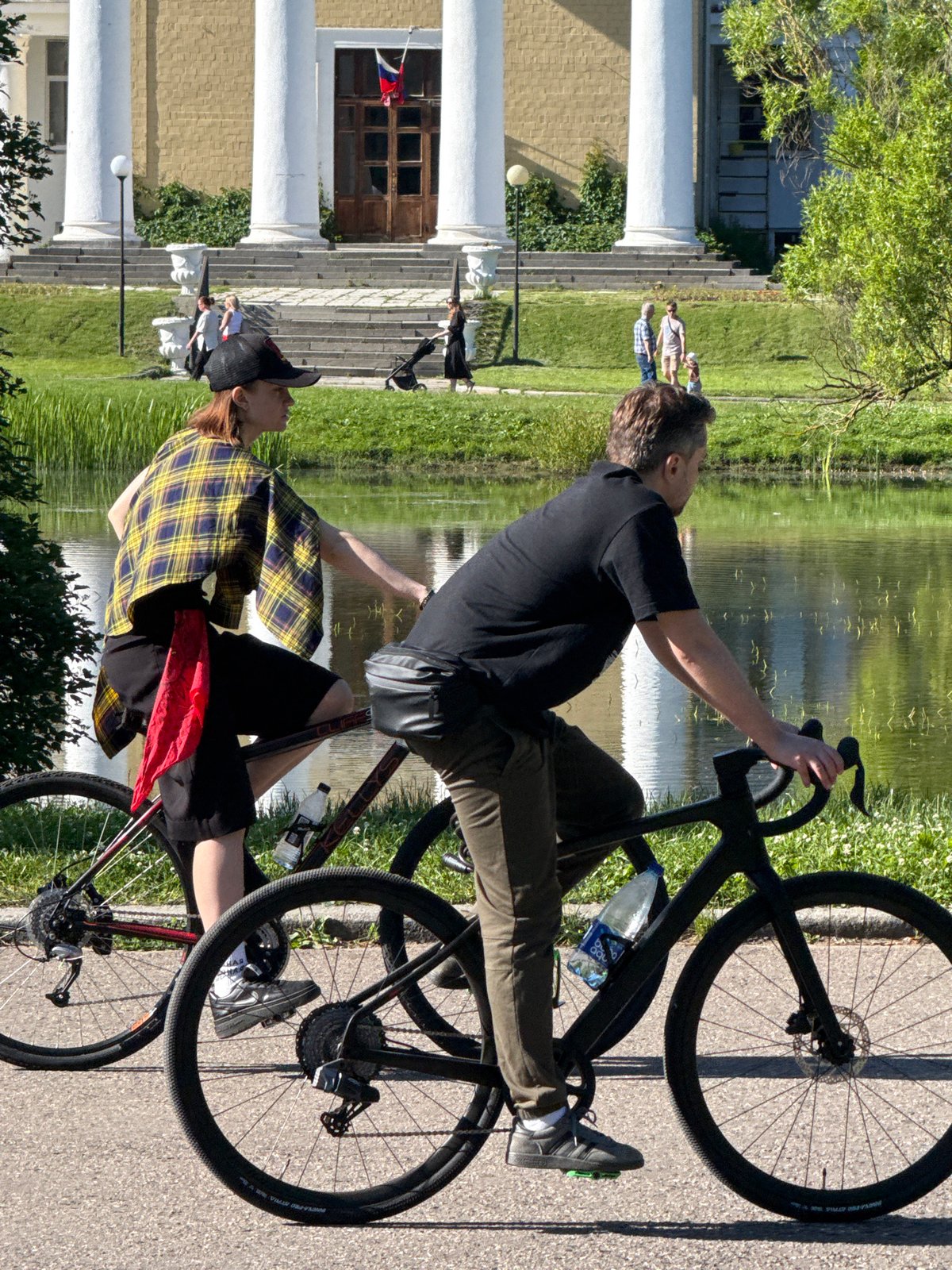Sunny afternoon cycling and strolling beside a Moscow park pond