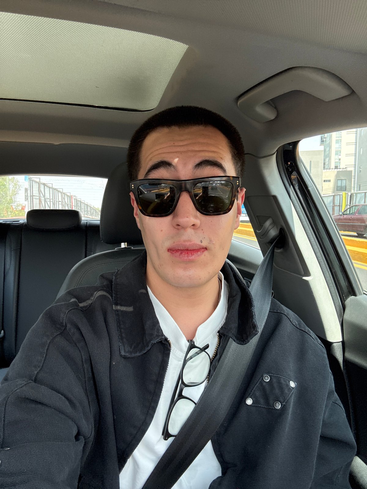 Young man photographed in car passenger seat in Puebla