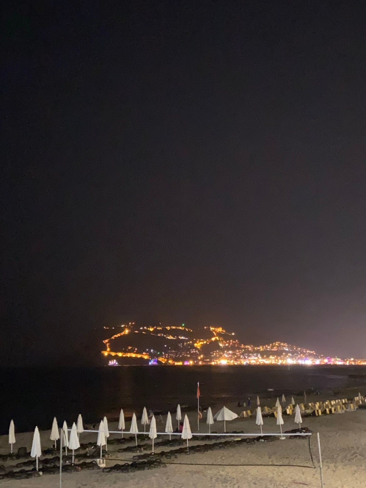 Alanya after dark: beach, moonlit sea, and city streets