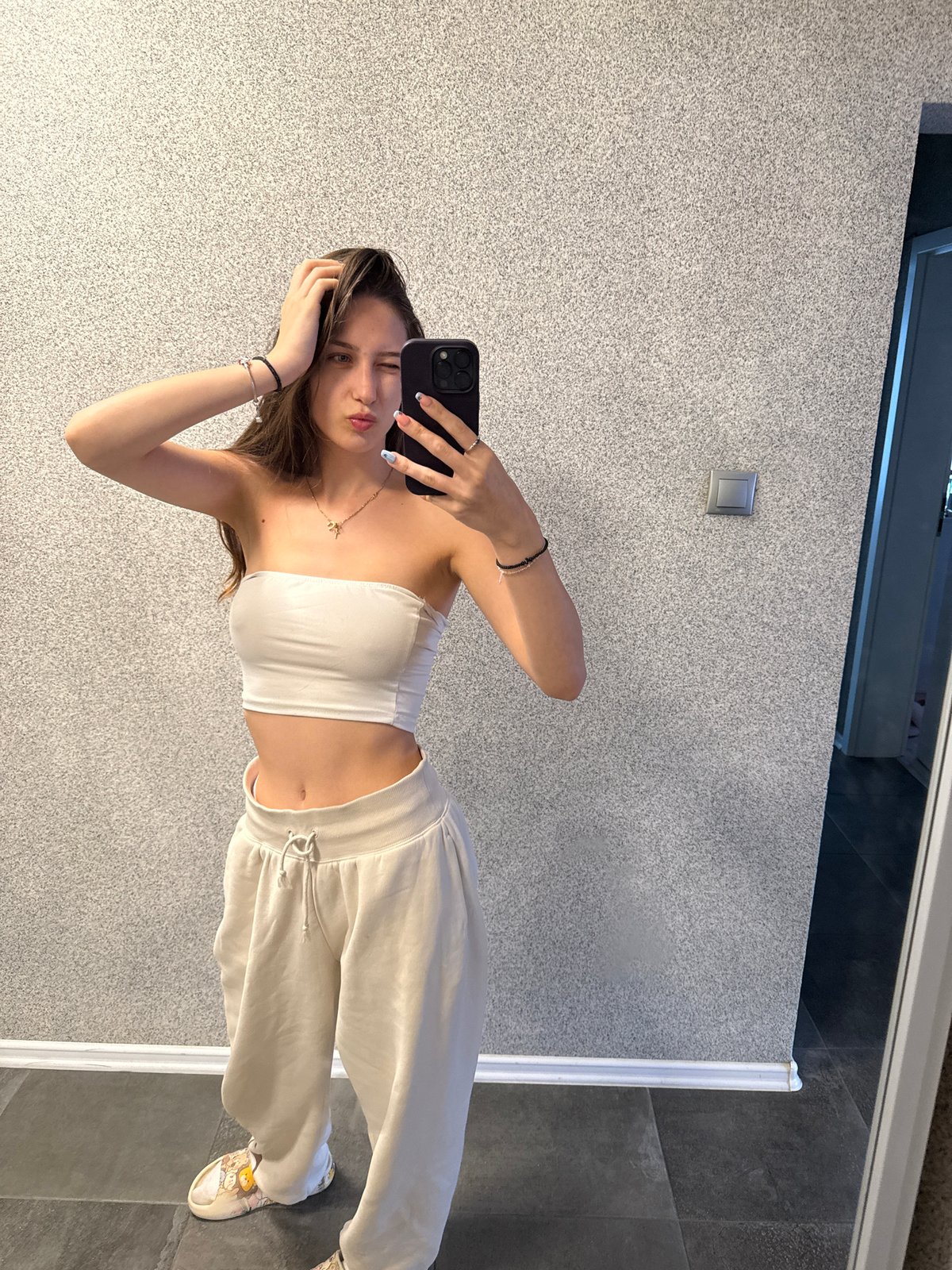 Woman takes mirror selfies, adjusts outfit in Sofia locations