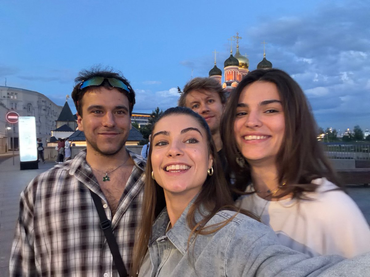 Young adults photograph themselves near Moscow memorial at dusk