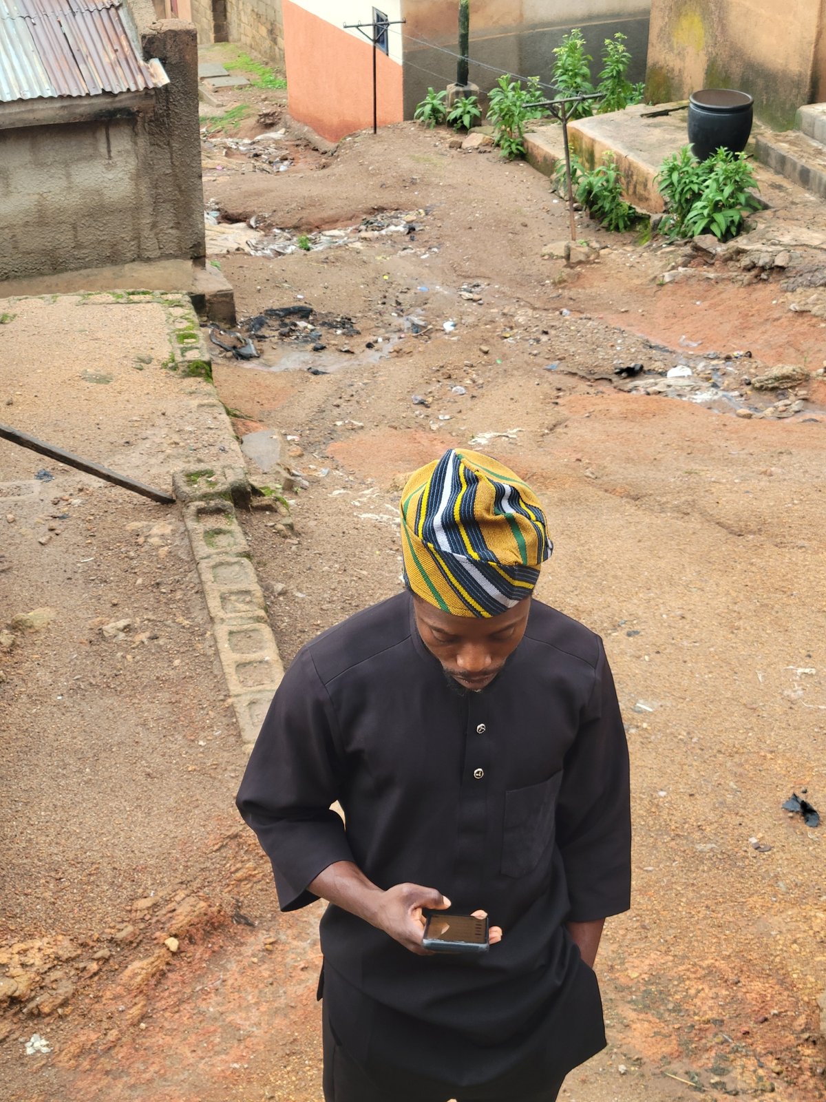 Traditional dress smartphone moment in urban settlement area