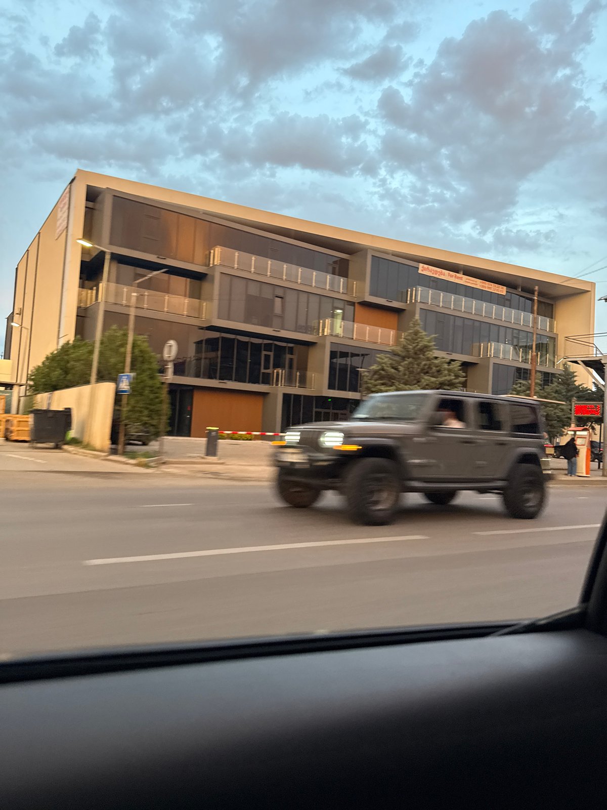 Evening drive through Tbilisi past construction, traffic, and wet streets