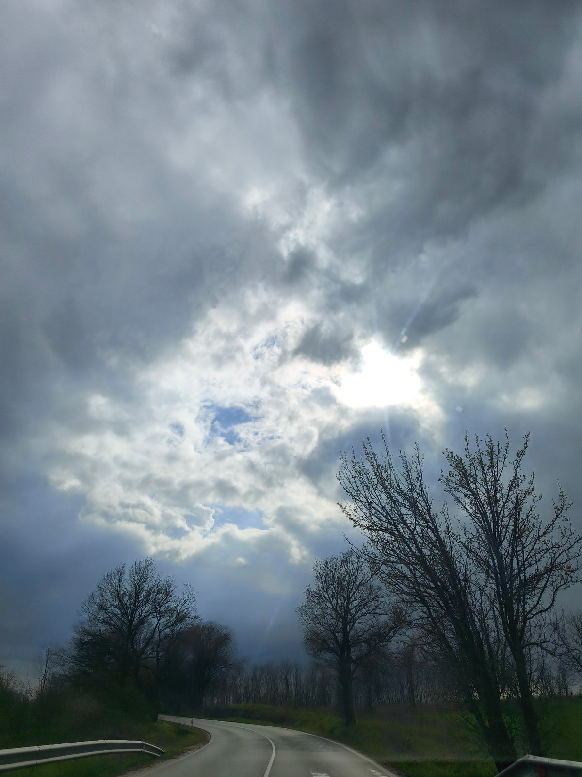 Storm clouds gather over Benkovski road with sunlight breaks